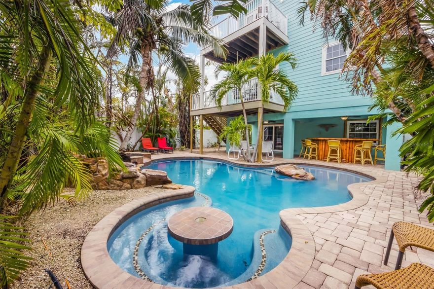 Don’t miss this opportunity to own one block to the gorgeous beaches of Holmes Beach!!!  Perfect for large families and groups, this 6-bedroom, 4.5 bathroom home has all the amenities you could want. With 10 ft ceilings, granite counters, and solid wood cabinetry, this property is ready to be a great second home or investment property. Step outside into your private tropical oasis to enjoy the oversized saltwater lagoon pool with a swim-up tiki table and large spa. Perfect for hosting groups under the large covered outdoor area and custom tiki bar after your day spent on the white sands of Holmes Beach.  Hurry and schedule your private showing today!