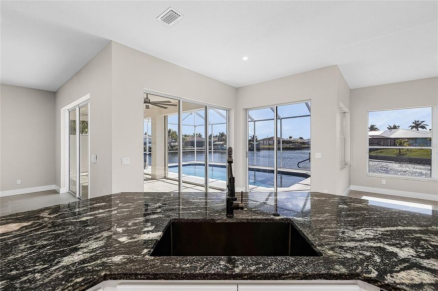 Extensively newly remodeled GULF ACCESS WATERFRONT home offers a rare blend of modern design, thoughtful upgrades, and lifestyle flexibility that stands apart from today’s repetitive new construction typical floor plans you see over and over. Featuring 3 bedrooms with one of the guest bedrooms drastically oversized, 2 bathrooms, a separate living and family room layout, and a 2 car garage. This home is designed for both everyday comfort and entertaining without having to worry about remodeling because just about everything has been recently redone. The bright open kitchen showcases custom soft close cabinetry, level 3 granite countertops, a very large non-traditional center island, new BLACK STAINLESS STEEL LG appliance package with 36 inch GAS COOKTOP and wall microwave wall oven combo with an impressive WALK IN BUTLER’s PANTRY complete with GLASS BARN DOORS, wine cooler, abundant storage, and additional countertop space. Oversized 24x48 porcelain tile flooring everywhere, recessed LED lighting, and expansive windows create a light filled interior with seamless indoor outdoor waterfront flow. The family room is anchored by a designer shiplap feature wall with gas fireplace with a striking marble look surround to be a focal point of the main living area. Both bathrooms have been fully updated with custom cabinetry, granite counters, black matt shower systems, LED mirrors, and beautifully tiled showers, while the primary suite offers a spa like retreat with a large walk in closet and shower with luxury high end elegant finishes. Major system updates include a newer roof, brand new AC system, full home re pipe, and updated lighting throughout, with SO MUCH MORE providing peace of mind for years to come. Outdoors, enjoy an OVERSIZED WATERFRONT LOT with seawall approximately 145 feet of Gulf access water frontage, a short boat ride to open water with only one bridge, and a brand new fully resurfaced pebble tech like with glass tile and newly installed stone coping solar heated pool framed by a screened lanai and amazing waterfront views. Additional highlights include a remodeled front façade, impact rated entry door, hurricane shutters, new landscaping, and transferable LOW COST FLOOD INSURANCE (approx. $1030/year). Located in a city water and sewer neighborhood surrounded by newer high value homes and a short bike ride or walk to the popular 7 ISLANDS PROJECT and local parks. Embers Pkwy is currently undergoing a “median beautification” and will have lush landscaping as you come into your wonderful neighborhood. This property delivers the space, character, and upgrades buyers want without settling for another identical floor plan, making it an ideal full time residence or luxury seasonal retreat. Please ask to see the full “Upgraded Feature List”. Buy this unique one of a kind home now before someone else does!