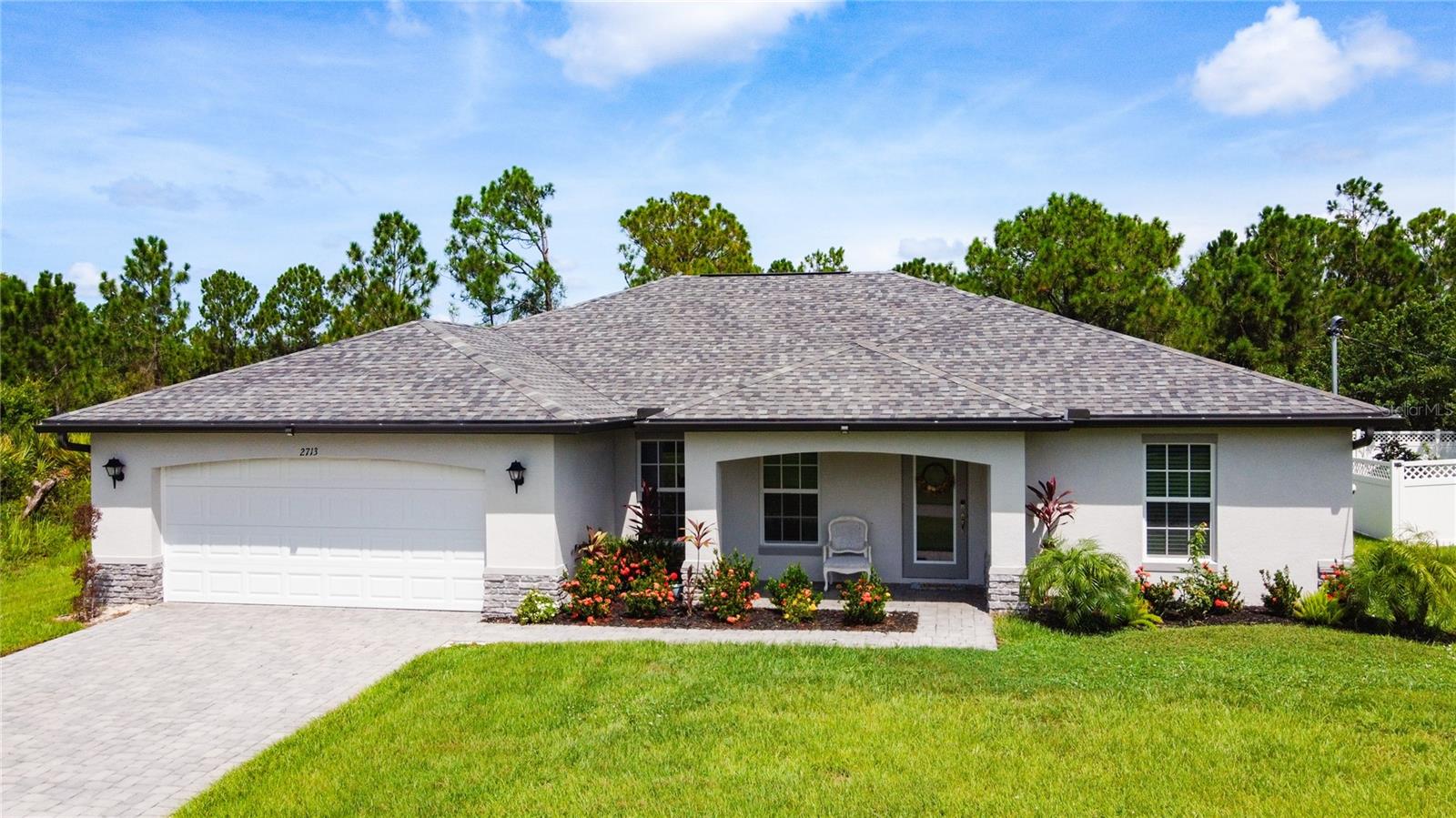 Welcome to your slice of paradise in North Port, Florida. This well-maintained home boasts an open floor plan with a neutral color palette waiting for your personal touch to claim it as your own. Vaulted ceilings and the open floor plan make this space ideal for entertaining. This two year old home features 4 bedrooms, 2 full bathrooms, a formal dining room, a living room, open kitchen concept, designated laundry room, covered and enclosed lanai, 2 car attached garage as well as closets galore for all your storage needs. Notable features include a 10 year transferable structural warranty (approximately 8 years remaining), PGT IMPACT Low E Insulated windows, high efficiency AC system, stainless steel kitchen appliances, tile throughout, 36” upper kitchen cabinets with soft close doors, granite countertops in kitchen and bathrooms, colonial style raised panel doors, stone accents on the front elevation of the home, irrigation system, epoxy garage floor and a beautiful paver driveway to accentuate outside features. The primary bedroom features an ensuite with walk-in shower and double sink vanities along with dual walk-in closets. The split floor plan includes three additional bedrooms on the opposite side of the home along with a full bath. Ample space for guests and family members or to create a home office. Sliding glass doors transport you from the family room to an outdoor covered and enclosed lanai with a ceiling fan to keep everyone cool while enjoying the scenery of a spacious and lush backyard. Conveniently located near local amenities with easy access to commuter routes as well. This home checks all the boxes so schedule a showing today!