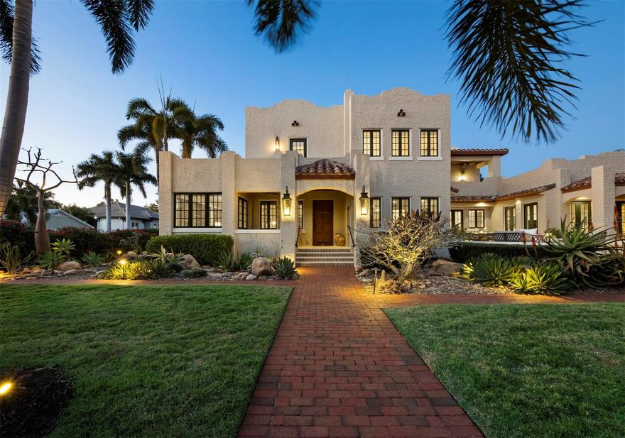 A historically designated home with the luxuries of modern renovation yet distinctive quality of its Mediterranean Revival style is located West of Trail in the Avondale community. Named for the first owners, William and Bessie Pearsall, the home was completed in 1925 and attributed to Thomas Reed Martin, the architect credited with Burns Court and other notable homes and buildings in the region. An expansion of the original home between 2005 and 2007 designed by architect W. Thorning Little added more than 2,000 square feet, combining meticulous preservation of moldings, floors and more with thorough modernization. Now encompassing more than 3,800 interior square feet with 4 bedrooms and 3 and a half bathrooms, as well as thoughtfully composed exterior spaces including a loggia and courtyard patio, the home presents openness and intimacy with abundant natural light that showcases both its modern comforts and unique original features. French doors throughout invite a seamless indoor-outdoor flow, connecting each living space to the lush established landscape and private yard with brick paths and a vibrant surround of bougainvillea and podocarpus that creates idyllic privacy. Conveniently positioned on the first floor, an enormous primary suite spans from a bedroom with space for seating and two walk-in closets to a spa-like en-suite with a soaker tub, walk-in shower, dual vanities with granite counters and a separate water closet. Upstairs, an alternative owners’ suite employs a massive en-suite with water closet, soaker tub, room-sized walk-in shower, dual vanities, and private access to the second-story terrace. Two additional bedrooms offer accommodation for family living or hospitality, with separate flex space adding utility as a personal gym, office, or media den. At the heart of the home, a total kitchen renovation in 2024 has added considerable value with exceptional design and topline appliances including a gorgeous La Cornue oven and range, custom Venetian plaster hood, paneled Subzero refrigerator, integrated Wolf microwave oven, Bosch dishwasher, deep Franke sink, bespoke Campbell Cabinetry cabinets, quartzite surfaces and a central island that overlooks double doors opening directly to the private patio. Complementing original details like hardwood flooring, a wood burning fireplace, leaded glass transom window and more, numerous recent enhancements include a newly painted interior, new designer light fixtures and window coverings, powder room renovation, restoration of the marble tile patio surface, landscape lighting, irrigation, and whole house water filtration. Exceptional functional upgrades include hurricane-rated windows and front door, tankless gas water heater, a new membrane roof (November 2024), solar panels optimally oriented and connected to PV Solar Electric system, and a Kohler whole-home gas generator. Located in the picturesque Avondale neighborhood that is prized for its proximity to Downtown and Selby Gardens and for its collegial feel, the Pearsall House presents a rare combination of comfort and character in a serene retreat with easy access to innumerable amenities.