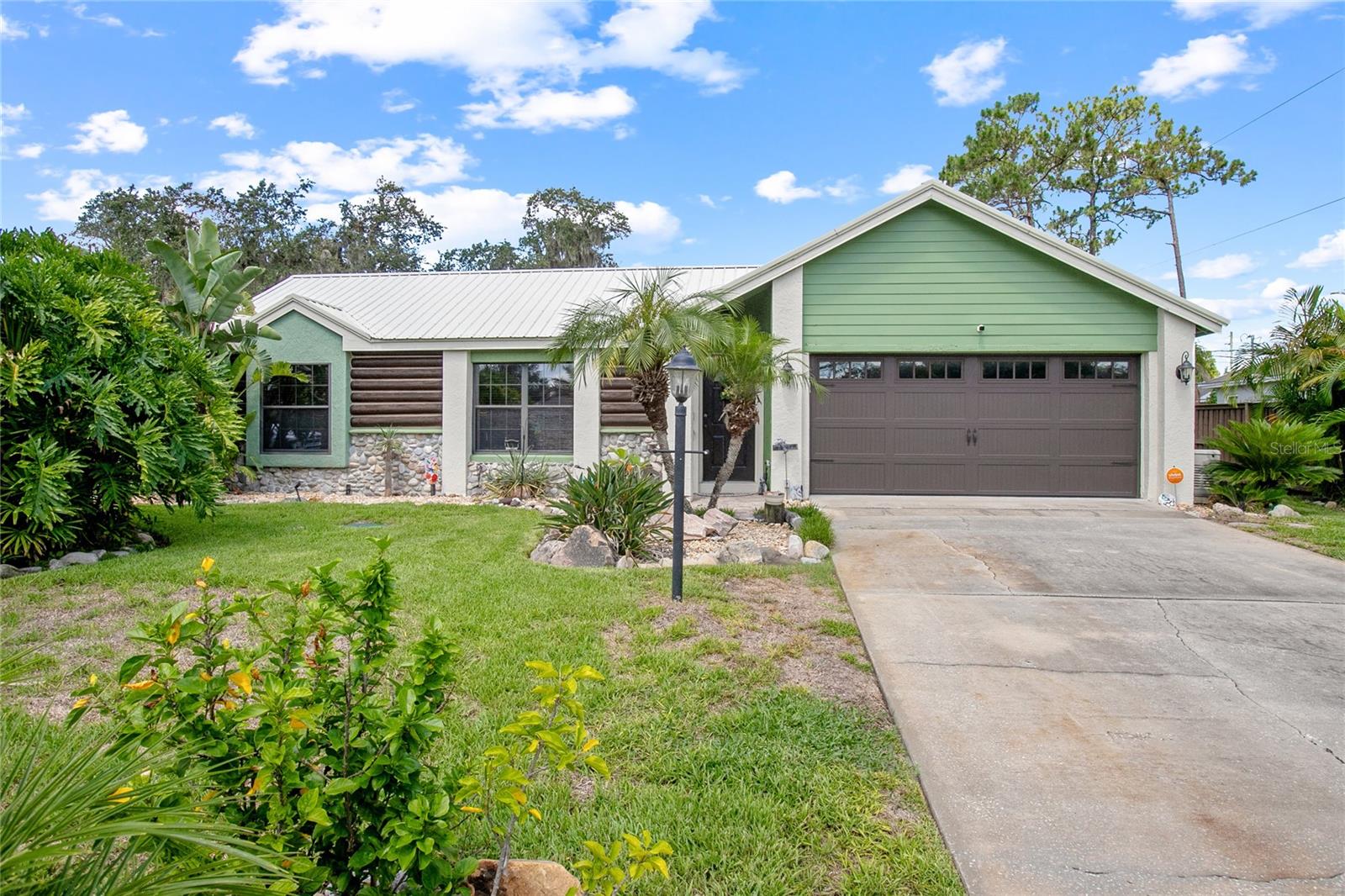 Don’t miss this unique opportunity to own a beautifully maintained 3-bedroom, 2-bath home in Deltona that includes a private 500 sq ft in-law suite—a rare gem in today’s market! Ideal for extended family, guests, or rental income, the suite features its own kitchen, private side entrance (plus interior access), a tankless hot water heater, and overlooks the sparkling saltwater pool—providing comfort, independence, and incredible versatility. Inside the main home, you’ll find a spacious split floorplan with rich hardwood floors throughout the main living areas, offering both warmth and durability. The two full bathrooms have been stylishly updated with tiled showers and glass doors. A screened-in back porch provides the perfect spot to unwind while taking in views of the tropical landscaping and serene pool area. Step outside to your own private retreat: the saltwater pool is surrounded by a paver patio, tropical trees, and winding paver walkways that make you feel like you’ve stepped into a resort. An outdoor shower is conveniently located poolside, perfect after a swim. Additional upgrades include St. Augustine grass, a full irrigation system, metal roof, a 2019 HVAC system, and a 22kW Generac generator powered by two 100-gallon propane tanks (maintained annually). The oversized 2-car garage features professionally installed cabinets for excellent storage, plus a hurricane-rated garage door for extra protection. Homes with in-law suites and resort-style backyards like this are incredibly rare—schedule your private tour today!