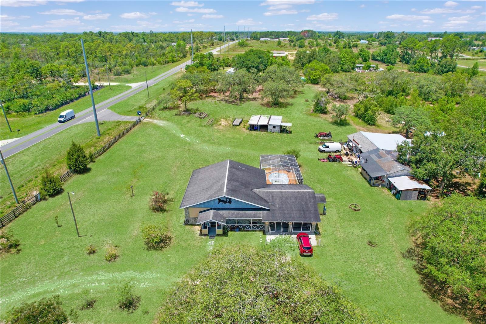 Opportunity meets potential on this slice of Florida countryside. 4.9 fully fenced acres at the corner of Hexam Rd and Sunshine Grove, this property offers the perfect blend of residential comfort, business potential, and recreational space. Zoned Agricultural, this property opens the door to a variety of farming or business ventures. Homesteading to horse boarding or nursery operations. It's prime location and frontage is currently zoned AG (Agricultural) and has a Future Land Use (FLU) designation of Rural, in accordance with the Hernando County Comprehensive Plan. Per the Comprehensive Plan, the Rural FLU designation allows for certain Neighborhood Commercial and Agricultural Commercial uses. AADT (Annual Average Daily Traffic) 14,500. Public water and sewer are available nearby. The home was custom-built by the owner, with 2 bedrooms, 2.5 bathrooms and was built to commercial code standards with electric wiring ran through steel conduit, 15-inch soundproof exterior walls, 12-foot high vaulted ceilings, and handcrafted Amish hickory cabinets. The open floor plan is perfect for entertaining, with a giant kitchen featuring an island for eating. Outside the cool epoxy deck has a deep private pool with an outdoor kitchen, a large screened-in lanai, and oversized ceiling fans, perfect for hosting family or clients. The property includes a horse barn, outdoor sinks, and fully fenced pasture with multiple gated entrances for easy access. The main workshop is fully powered and features a half bath, air lines, and plenty of shelving, ideal for running your business. Perfect set up for car enthusiasts, electricians, woodworking, powder coating, or storage. An additional building functions as an office, extra storage, or flex space. This is a rare opportunity for entrepreneurs or hobbyists to run their operations from home. The property has a second septic tank for RV hookup. Currently zoned AG this property is one of the last in the area that allows for a mini-farm, with the potential for future commercial zoning. Setback Grandfathered at only 75 ft from road center. Approved uses may include farm implement sales, agricultural supply, feed store, or even a place of worship. With Sandal Key being developed nearby, this is a rare opportunity to own 4.9 acres with no HOA, unmatched space, and future potential in a rapidly growing area. Located just minutes from Weeki Wachee Springs, US-19, SR-50, and the Veterans Expressway, you're close to Publix, restaurants, gyms, and beaches while still enjoying a peaceful rural setting. Everything you need is minutes away!! So much potential for this property! Call today for more details.