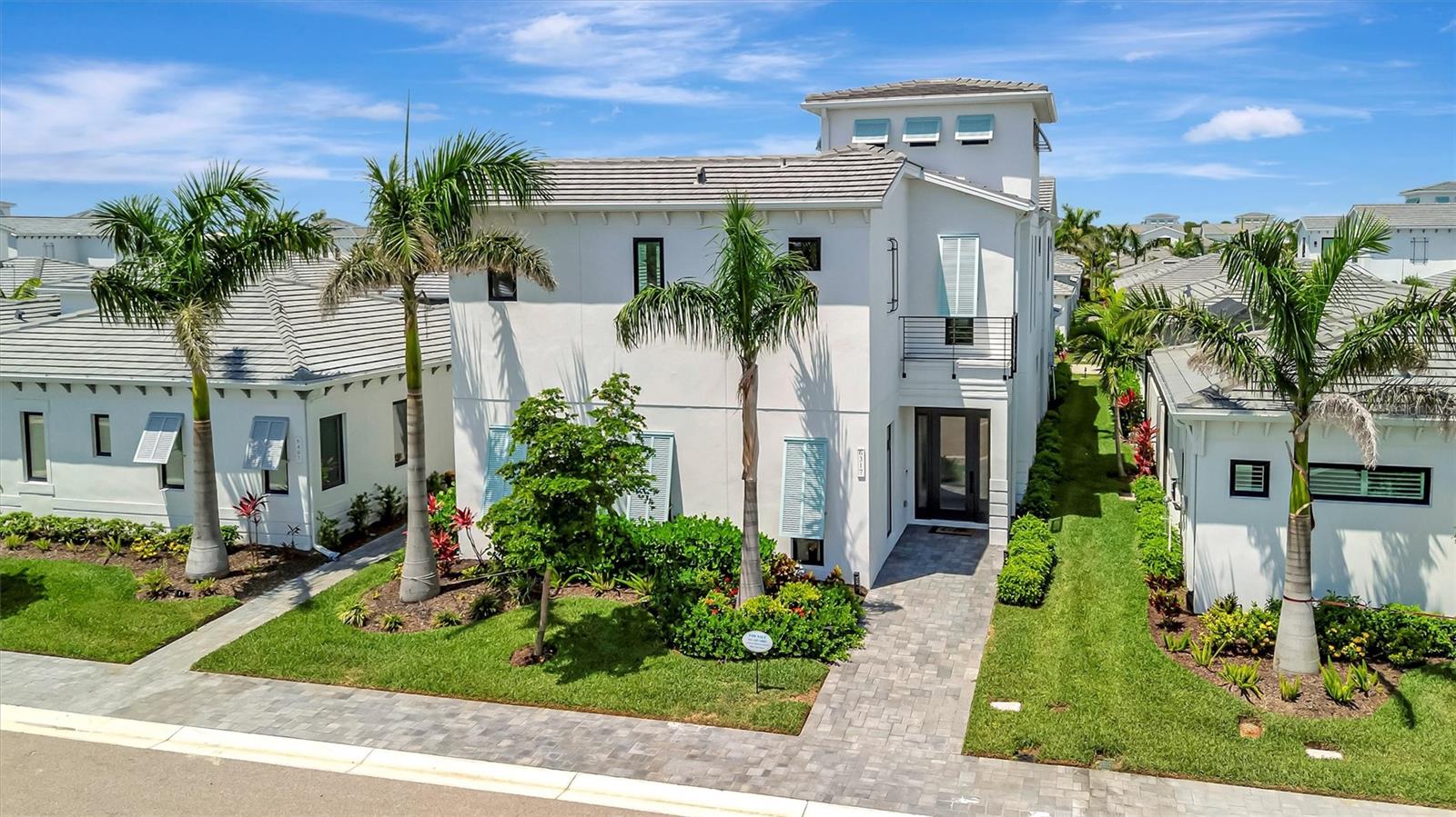 Experience elevated coastal living in this stunning two-story FULLY FURNISHED modern luxury home, ideally nestled in the sought-after Aqua Lagoon community—where tropical beauty meets contemporary sophistication. Spanning 3,916 square feet of meticulously designed space, this architectural masterpiece offers 3 bedrooms, 4 full bathrooms, a versatile loft, an office/den, and a spacious bonus media room perfect for entertaining or relaxing in style. All flexible spaces that can easily be converted to additional bedrooms offering the potential of a 6-bedroom home per the new owner’s preference. Step inside to soaring ceilings, a custom stairway with sleek lines, and designer finishes that define every inch of this residence. The heart of the home features a courtyard highlighted by a heated saltwater pool with a custom waterfall – truly your own private oasis for sun-soaked afternoons or evening gatherings under the stars. With seamless indoor-outdoor flow, there is direct slider access to an oversized media room as well as the chef-inspired kitchen providing the dream atmosphere for entertainment and family gatherings. The kitchen is outfitted with premium appliances including a built-in oven and microwave, solid wood cabinetry, a pantry closet, and a natural gas cook top in the oversized island that opens up to living area bathed in natural light. A private office sits just off the living room providing a peaceful retreat for remote work or a convenient flex space for multiple uses.
Down the hallway is a full-size bathroom with direct access to the pool courtyard as well as a formal dining room space with pool views through the extended windows and additional sitting space under the custom stairwell, perfect for enjoying a good read or conversation. Upstairs two of the three generously sized bedrooms boast private balconies with views of the serene courtyard and pool, creating a resort-style atmosphere right at home, while the loft offers a flexible space for family living, entertainment, or guest accommodations. In addition to your own private balcony, the master suite features an extended walk-in closet, and a spa-like retreat for the bathroom featuring separate vanities, free-standing soaker tub, and an oversized walk-in shower with dual shower heads. The second bedroom features a en-suite bathroom with shower tub combo and the third bedroom sits conveniently next to a full bathroom. A full laundry room is located on the second floor for ease of access. New owner will be able to take advantage of the full home UV lighting HVAC as well as a hospital grade water filtration system that runs throughout. The epoxy floor garage with built-in overheard storage, features a rare third flex space that’s perfect for additional storage, golf cart parking, or a third car parking spot. This vibrant coastal community is centered around a stunning 4-acre crystal-clear lagoon, promising luxury, leisure, and lifestyle all in one. Aqua lagoon is conveniently located near world renowned IMG Academy, IMG Golf & CC, Anna Maria Island, Cortez Village, and SRQ airport, while remaining a short drive away from shopping and entertainment districts such as UTC and St Armand’s Circle. All providing the perfect location and atmosphere for your personal home, private FL retreat, or annual rental investment. Beat the wait for a new build and schedule your private showing of this stunning FULLY FURNISHE home!!!