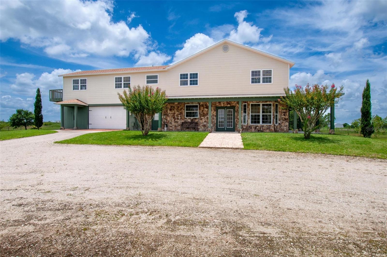 Welcome to your dream escape! This beautifully custom built 3-bedroom, 2.5-bathroom home offers the perfect blend of comfort, space and privacy, all nestled on 5 acres of lush, open land. From the moment you arrive, you'll be drawn in by the homes charming stone-accented facade, a spacious wraparound porch, and serene views in every direction. Inside the home boasts a thoughtfully designed floor plan with generous living spaces, ideal for both entertaining and everyday living. At the heart of the home is a stunning fireplace, crafted to match the exterior's unique masonry - a warm and eye-catching centerpiece that brings the rustic charm and charter to the living space. The wood flooring is a showstopper, adding warmth, durability and timeless style throughout the living room, staircase, landing and the bedrooms. The natural lighting in this home is unlike any other. The kitchen features rich wood cabinetry, a center island, and ample space for gathering. Just off the kitchen, the laundry room continues the high end feel with matching custom cabinetry, offering both beauty and practical storage. This property is a true oasis, complete with a large private pond, winding driveway, and mature oak trees. There's also plenty of room for gardening, livestock, or building additional storage structures - perfect for those seeking a self-sufficient lifestyle. Whether you're looking to relax on the porch and enjoy the sunrise, host gatherings in a spacious interior, or explore the possibilities of wide-open land, this one-of-a-kind property delivers. This is more than a home, it's a private retreat designed for comfort, style, and self-sufficiency. This home had a ne roof installed in 2023. Come see all the ways this exceptional property can fit your lifestyle. There is an additional 5 acres that can also be sold making this a 10-acre dream home and property.