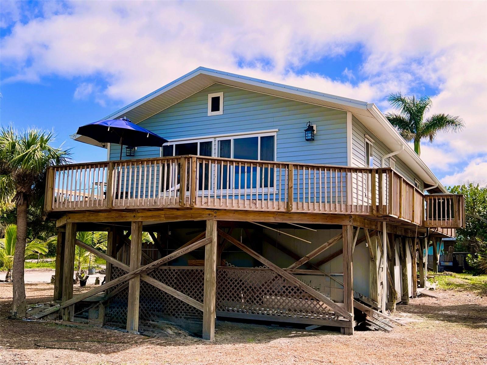Your Beach Retreat on Little Gasparilla Island awaits you. Imagine waking up on the quiet north end of Little Gasparilla Island, where the sound of the waves and the rustle of palms replace traffic and noise. This inviting 3-bedroom, 2-bath island home sits on a spacious corner lot and gives you everything you need to step straight into the beach life. With deeded beach access just steps away and a community dock (first come, first served, just $300/year), your days can be spent on the sand, on the water, or entertaining friends on the porch. Inside, the home is open and welcoming, with a large kitchen flowing into the dining and living area, perfect for hosting family dinners or gathering with friends. The dining table seats eight, and the oversized sectional makes room for everyone after a long day of boating or beachcombing. Step outside to a breezy front porch for morning coffee, or retreat to the covered back porch where you’ll find an outdoor dining space and grill area designed for relaxed evenings. After the beach, rinse off in the outdoor shower with hot and cold water, then tuck away your gear in the ground-level storage, perfect for fishing tackle, tools, and beach toys. This home has been thoughtfully updated in the last couple of years with a new roof (2023), A/C, flooring, paint, appliances, lighting, bathroom finishes, and much more, giving you peace of mind and modern comfort from the moment you arrive. Even better, it’s being sold fully furnished and completely turn-key, all you’ll need is a toothbrush and flip-flops. If you’ve been dreaming of a place where the beach is your backyard, the neighbors wave hello, and the fishing is world-class, this Little Gasparilla escape is waiting for you. Pack your bags, your island life starts here.