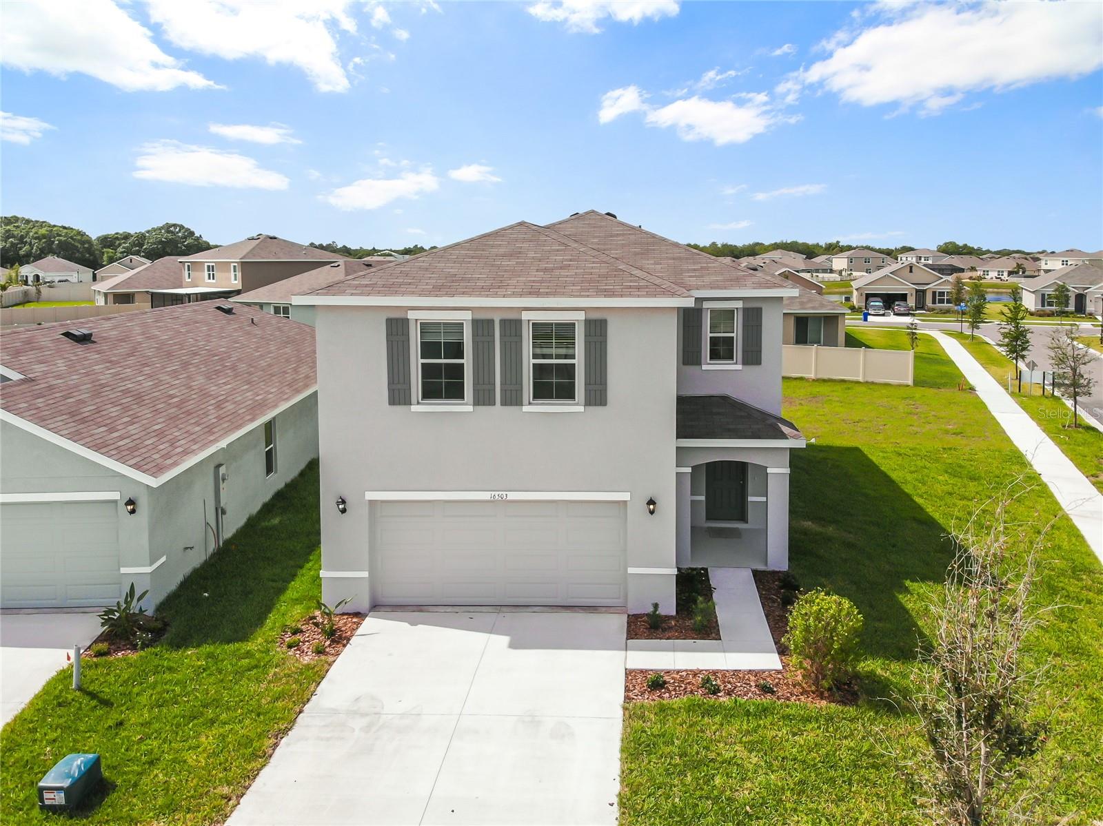 Welcome home! This newer construction, two-story concrete block home is waiting for its first tenant! This colonial features four bedrooms plus a loft, two and a half bathrooms, and a two-car garage in the Sereno community. The first floor has 18x18" gray tile throughout and plush carpet on the second floor. The modern kitchen features cabinetry with granite countertops and stainless steel appliances. The kitchen island with a breakfast bar is the focal point of this open-concept home. The main floor powder room and walk-in pantry are great for everyday essentials. The living room/great room leads out to the patio and backyard. The second floor opens to a loft with 3 generously sized bedrooms. The master bath has a double vanity with a soaking tub. The master suite features a large walk-in closet, a private bath with a shower, and a double vanity. Lots of natural light with large windows on all sides. The home is situated on a corner lot on a cul-de-sac. This is one of the largest lots in the neighborhood. Gated community amenities include an open-air clubhouse, swimming pool, playground, dog park, walking trails, tennis court, and basketball court. The community is centrally located near shopping, schools, and parks.
