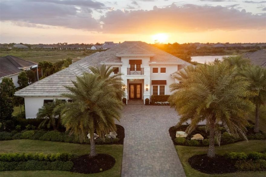 Experience elevated Florida luxury in The Lake Club with this exceptional Stock Signature Gardenia III residence, offering 4,139 square feet of meticulously customized living space. Designed to seamlessly blend indoor and outdoor living, this open-concept home features 4 bedrooms plus a den and expansive bonus room, along with 5.5 baths—each bedroom boasting its own private ensuite. From the moment you enter through the double iron doors, you’re welcomed by a stately foyer and grand great room with soaring 15-foot coffered ceilings, refined by crown molding, porcelain tile flooring, designer lighting, and solid core doors throughout. At the heart of the home, the chef’s kitchen impresses with Britannica Cambria quartz countertops, a massive island with additional storage, upgraded JennAir stainless steel appliances, custom modern vent hood, under-cabinet lighting, and a walk-in pantry with wood shelving. The adjacent dining space is highlighted by a striking glass-encased illuminated wine wall, perfect for entertaining. A private casita—accessible from the lanai—offers a full ensuite bath and kitchenette with beverage cooler, ideal for guests. Step outside to an expansive marble-tiled lanai featuring a gas fireplace with newly installed custom tile surround, outdoor entertainment center, and a fully equipped summer kitchen with bar seating, grill, sink, and beverage cooler. Panoramic screens frame tranquil preserve and stunning sunset water views with complete privacy. The resort-style saltwater pool is a showstopper, complete with LED lighting, Pentair gas heater with smart capabilities, sun shelf, spa, swim-out bench, and elegant deck jets. The luxurious primary suite is a private retreat with seating areas, French doors to the lanai, dual walk-in closets with custom showcase organizers, and a spa-like bath with freestanding soaking tub, dual vanities, and walk-in shower. A versatile bonus/media room offers a waterfall-edge dry bar, beverage cooler, ensuite pool bath, and walk-in closet—perfect as a fifth bedroom or entertainment space. Additional highlights include a 3-car side-entry garage with epoxy floors, mini-split AC, high-lift door for car lift capability, and added blown-in attic insulation. Tech aficionados will appreciate the Sonos sound system throughout the home and Uxari security system. Hurricane impact windows, sliders, and doors provide peace of mind. The home is further equipped with an in-wall pest control system for added convenience, as well as a Culligan hybrid water softener and whole-home filtration system for enhanced water quality. Recent upgrades include professionally sealing the driveway and lanai, along with a preventative roof treatment designed to inhibit organic growth and maintain long-term curb appeal. Over $500,000 in premium upgrades, including $75,000 in lush, enhanced landscaping, this home is a showstopper! With no neighbors in sight and thoughtfully curated high-end finishes at every turn, this one-of-a-kind residence delivers the ultimate in privacy, sophistication, and Florida lifestyle living.