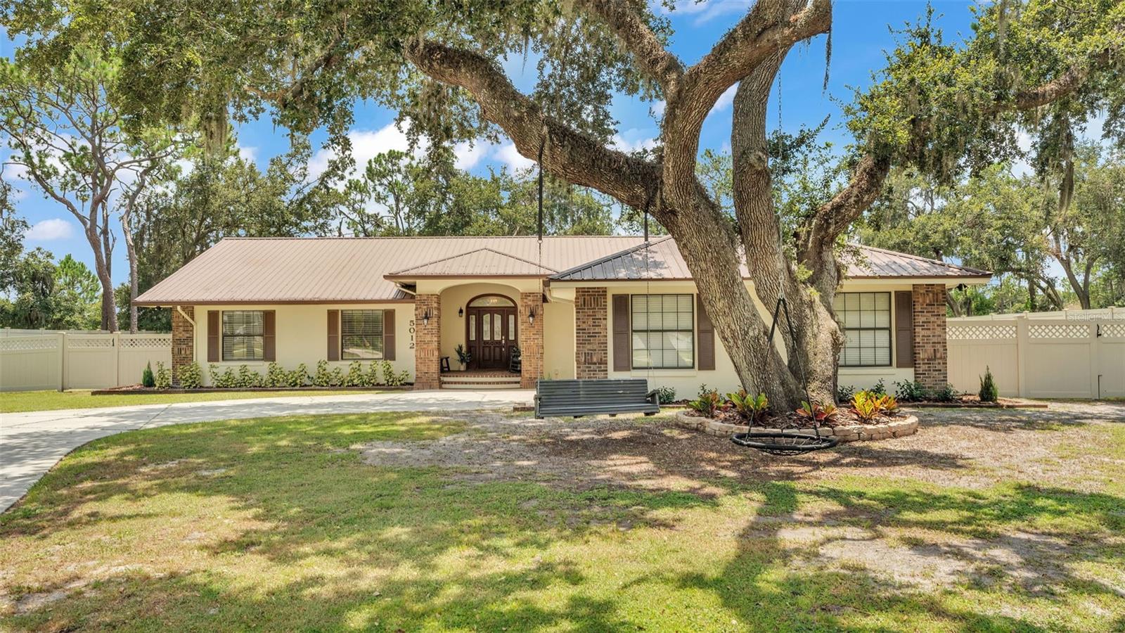 This stunning 3-bedroom, 2.5-bathroom pool home with a spacious office is nestled on a full acre of land in a quiet, golf cart and horse-friendly neighborhood—just 15 minutes from Downtown Lakeland and offering easy access to Tampa and Orlando via I-4. With no rear neighbors and surrounded by an 8-foot privacy fence, this beautifully remodeled home offers peace, charm, and modern comfort in every detail. Step inside to find a bright open floor plan with vaulted ceilings, real hardwood flooring, and abundant natural light. The expansive living and dining areas seamlessly flow into a fully updated kitchen—perfect for entertaining. A 2021 renovation brought stylish updates throughout, while the oversized flex room serves perfectly as a home gym, office, or even a fourth bedroom. Retreat to the luxurious primary bedroom suite featuring two walk-in closets, dual vanities, a large clawfoot tub, and a brand-new frameless glass shower. Two additional bedrooms and baths provide comfortable space for family or guests. Outside, your private backyard oasis awaits. A durable metal roof adds long-term value and peace of mind, while a freshly painted exterior and beautiful landscaping enhance the curb appeal. Relax on the wooden swing beneath the large front-yard tree, or enjoy evenings around the gravel rock firepit. The spacious front and back yards offer room to roam, garden, or keep chickens—while the large solar-heated saltwater pool with screened enclosure and covered patio makes Florida living effortless. A large driveway with plenty of parking space, including an additional pad for your RV, trailer, or boat, provides convenience and flexibility. The oversized garage, newer energy-efficient AC unit (2025), and security camera system add comfort and functionality. This home is nestled in a peaceful, nature-filled setting where you can unwind and recharge—yet it's part of a welcoming community with events like the annual Christmas golf cart parade. Just minutes from Walker Road Park with soccer fields, softball diamonds, and scenic trails, this is a rare opportunity to enjoy tranquil country living with unbeatable city convenience. Call today to schedule your private showing!