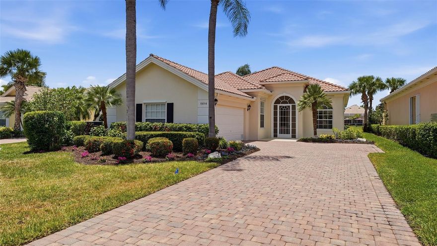 Welcome to the good life at VillageWalk in Palmer Ranch, where resort-style amenities, calming water views, and low-maintenance living create the perfect Sarasota lifestyle. This beautifully maintained turnkey-furnished 3-bedroom, 3-bath home with a den/office offers approximately 2,200 square feet under air (2,695 total square feet) and sits on a lovely homesite with a tranquil water view. An oversized screened lanai enhances the home’s seamless indoor-outdoor living experience. Inside, soaring ceilings, multiple sliding glass doors, and rich wide-plank walnut hardwood flooring create a bright and welcoming feel. The spacious kitchen features granite countertops, abundant cabinetry, glass tile backsplash, breakfast bar seating, and an easy flow into the main living and dining areas. The private primary suite offers serene pond views, dual walk-in closets, and a unique dual-bath design with separate vanities and commodes connected by a shared walk-in shower with pocket doors for privacy. A split-bedroom floorplan provides comfort for guests, while the separate den/office offers flexibility for working from home, hobbies, or additional guest space. Step outside to the expansive screened lanai where an electric awning provides welcome shade and protection on hot Florida summer days, creating the perfect place for morning coffee, evening wine, or simply enjoying the view. Additional highlights include newer AC (2021), hurricane shutters and tinted glass, central vacuum system, underground utilities, and the unmatched quality of DiVosta’s steel-reinforced poured concrete construction, all located in a no-flood zone for added peace of mind. The exterior has also been beautifully refreshed with fabulous new landscaping, freshly painted concrete, and a fully pressure-washed outdoor space. The sellers have thoughtfully prepared the home for its next owners with a pre-listing inspection already completed and every recommended repair addressed. The buyer will receive the inspection report along with receipts and photos of completed work. Residents of VillageWalk enjoy miles of scenic walking paths and bridges throughout 500+ acres of lakes and preserves, along with heated lap and lagoon-style pools, tennis and pickleball courts, a 24-hour fitness center, café, gas station, salon, gift shop, post office, and an active social calendar. Ideally located just minutes from the Legacy Trail, downtown Sarasota, shopping, dining, and world-famous Siesta Key Beach. Carefree days. Peaceful pond views. Effortless Sarasota living begins here.