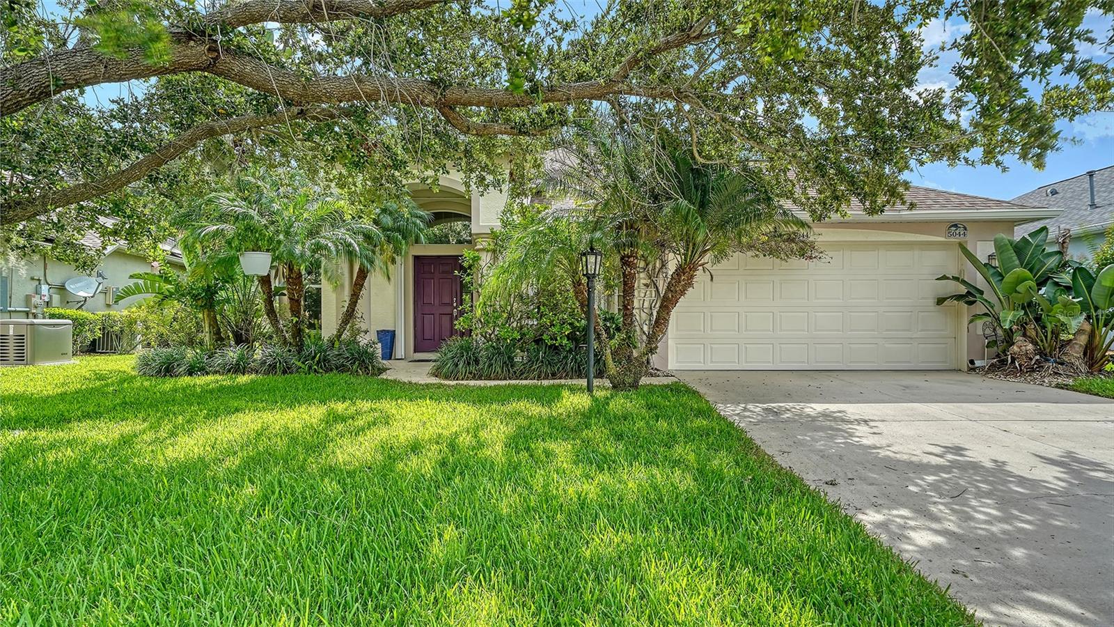 Welcome to 5044 Creekside Trail, in the desirable Carlyle community of Palm Aire. This beautifully updated three-bedroom plus den home on a private preserve lot with a tranquil creek running just beyond the backyard, offering serenity and privacy. Enter to discover an open and spacious floor plan filled with natural light and several updates. A newer roof (2020), HVAC system (2020), and energy-efficient solar panels (2020) keep monthly electric bills averaging just $30 a month. New carpets in both guest bedrooms (June 2025) and fresh interior painting—including walls, ceilings and baseboards (June 2025)—give the home a crisp, modern feel. Luxury laminate flooring flows throughout the main living areas. The kitchen features warm wood cabinetry, newer stainless steel appliances, and a casual dining nook, all open to the family room with sliding glass doors leading to an extended lanai—ideal for relaxing or entertaining family and guests. The primary suite, accessed through double doors, offers a spacious retreat with a walk-in closet and en-suite bath featuring dual sinks, a soaking tub and a separate walk-in shower. Enjoy working from home in the generous private den, thoughtfully enclosed by French doors for added privacy and a quiet, focused workspace. Other features include accordion rollout hurricane shutters on all exterior doors and windows, a fenced-in backyard, tray ceilings, lush tropical landscaping, including tall palms and mature vegetation, to complete the Florida lifestyle you've been dreaming of. Residents at Carlyle at The Villages of Palm-Aire enjoy low HOA fees, less than $90 per month, and no CDDs. Great amenities such as pickleball, tennis courts, a community pool, a playground, and option to join the Palm-Aire Country Club. Great location near UTC Mall, shopping, restaurants, Sarasota International Airport, and downtown Sarasota and the sugary beaches.
