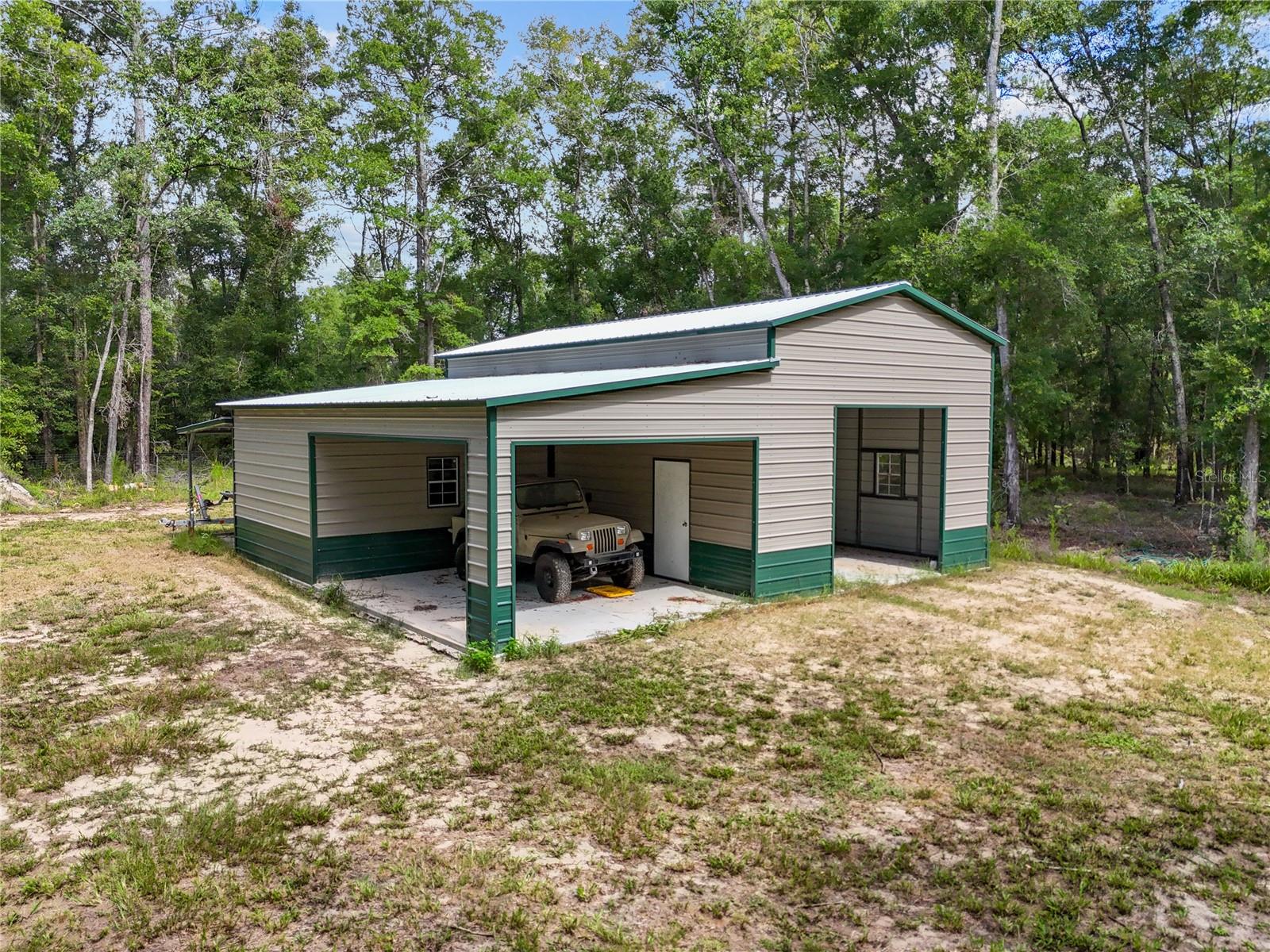 This 6.7 acre lot is located between High Springs and Newberry in a part of Alachua County where large farms and tracts of land still exist. The mature oak and pine canopy gives way to a new metal building in the center of the property that would make the perfect beginning to a barndominum project. The building features a large shop area with high bay opening, an attached room (perfect for a studio apartment), a covered carport and plumbing already stubbed up in the slab. An old single wide mobile home also sits on the property and is serviced by the existing electric, well and septic. All of the hard work is done and this property is ready for your final touches. This is a great opportunity to build sweat equity in a desirable location and cash in one day down the road or for full time RV’rs to establish a “home base”. Call today for more details or to schedule a viewing.