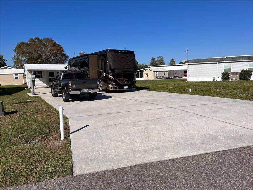 Discover a rare opportunity to own a deeded Class A motorhome lot and a half in the highly desirable Phase 1 of Mount Olive Shores.

This expansive 27’ x 83’ concrete pad is engineered to accommodate virtually any size motorhome and is fully equipped with 200-amp service and complete public RV utility hookups on both sides — delivering immediate functionality and maximum flexibility.

Turnkey Comfort with Finished A/C Shed

Enhancing the property is a beautifully finished 20’ x 11’ air-conditioned shed, thoughtfully designed for comfort and extended living. Inside, you’ll find:
 • Inviting living area with queen sleeper sofa
 • Mini refrigerator & microwave
 • TV, ceiling fan, wall mirror
 • Computer desk and chair
 • Two end tables with lamps
 • Fully equipped bathroom featuring:
 • Stacked washer and dryer
 • Shower & toilet
 • Deep sink
 • Hot water heater
 • Exhaust fan

This space functions perfectly as a guest retreat, lounge, hobby room, or private office.

Future Expansion Potential

The oversized lot provides ample room to add a double-wide manufactured home and an RV port, allowing you to customize the property to match your long-term lifestyle goals.

Community & Lifestyle

The annual HOA fee includes basic lawn care and common area maintenance, ensuring a well-kept and visually appealing environment year-round.

Located just 3.5 miles from I-4, Mount Olive Shores offers quick access to shopping, premier medical facilities, both Tampa and Orlando International Airports, and Central Florida attractions — all within approximately one hour.

Residents also enjoy a brand-new 5,000-square-foot heated and cooled Community Center, featuring:
 • Full kitchen
 • Regulation pool & shuffleboard tables
 • Dart board & arcade games
 • Dedicated card room
 • Library
 • Vending area
 • Covered BBQ lanai

A full calendar of seasonal activities — including bingo, karaoke, potluck dinners, holiday celebrations, and numerous social events — creates consistent opportunities for connection and engagement.

As a deed-restricted community, ownership or Lease of a Class A motorhome is required your first year of residency, preserving the integrity and exclusivity of the neighborhood.

This is a strategic opportunity to secure premium RV property in one of Central Florida’s most established Class A communities.