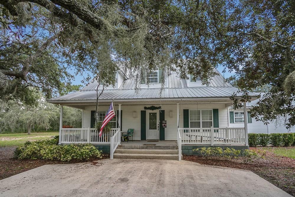 Looking for the privacy of a tranquil natural sanctuary with acres to call your own? Welcome to 8077 Lake Hatchineha Rd – a custom-Built 2,612 square feet, 3-Bed, 2-Bath luxurious home on 5+ private acres of land! Bask in the shade of mature trees and scenery of the natural landscape as you cruise down the winding driveway right up to the front porch. Enter into the spacious single-level layout with vaulted ceilings and an open-concept great room—ideal for entertaining or relaxed family living. Prepare your meals in the gourmet eat-in kitchen featuring recessed lighting and bright skylights as well as a center island/breakfast bar, walk-in pantry, stainless steel appliances, the gas range with outside vent hood is a chefs dream! Serve meals and entertain your guests from the kitchen island complete with a wet bar. A separate dining space offers views of the secluded back yard and is adjacent to the living space with French doors opening to a screened lanai—permitting seamless indoor-outdoor living. The owner's suite is a quiet indoor retreat boasting French doors to the rear patio, a walk-in closet, and a well-appointed en-suite bathroom with skylight and glass-enclosed shower/tub. Luxury Vinyl flooring throughout common areas adds a sense of style underfoot.The screened lanai comes complete with an outdoor kitchen and plenty of space for seating, as well as a backyard built-in barbecue pit—perfect for holiday gatherings outdoors in serene surroundings. Step outside the screened lanai to enjoy cool morning breezes and feed the birds or the tortoise that call this beautiful property home. Bring all of your toys and treasures and just try to fill up the unbelievable amount of storage both inside and outside this home including extra large closets, attic access, the inside laundry, and exterior pole barn and sheds. The detached covered parking and pole barn, workshop, and storage sheds are the perfect compliment to this secluded countryside setting on 5.23 acres—ideal for nature enthusiasts, hobby farming, or creating your own outdoor paradise. You can have the best of both worlds, rural charm with access to local equestrian trails and nearby lakes—yet still close to Haines City amenities, schools, shopping, and major roadways. Enjoy the company of like minded neighbors in the string of custom-built homes along Lake Hatchineha Rd, demonstrating the prestige of this desirable location.You’ll Love this custom-built gem that offers country-living and luxury on over five tranquil acres—featuring a spacious, thoughtfully designed floor plan, high-quality finishes, with room for your toys and hobbies. Whether you're seeking serene privacy or generous entertaining space, this home checks all the boxes.Interested in exploring this unique property? Don't wait! Let’s talk today!