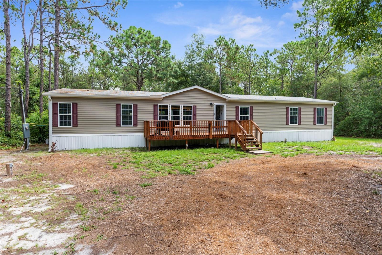 One or more photo(s) has been virtually staged. PRIVATE 5-ACRE MULTI-FAMILY COMPOUND WITH POOL, COMMERCIAL-GRADE WORKSHOP & HORSE-FRIENDLY ZONING! This rare multi-generational property offers TWO SEPARATE PARCELS totaling 5 ACRES in a PRIVATE & SECLUDED setting on the Pasco/Hernando County line, just minutes from the Suncoast Parkway for an easy commute. With NO HOA, this fully fenced estate with ELECTRIC GATE is ideal for horses, livestock, and COUNTRY LIVING while keeping modern conveniences close by. This 1 ACRE parcel - 5BR/3BA Manufactured Home built in 2019 which offers 2,128 square feet featuring an OPEN FLOOR PLAN, large kitchen with KITCHEN ISLAND, spacious LAUNDRY ROOM/MUDROOM/STORAGE ROOM. The primary suite includes a GARDEN TUB, DUAL SINKS, and a separate shower, and Walkin Closet. The split plan offers privacy and generously sized bedrooms, large closets, and a front DECK make this a perfect GUEST HOUSE or MULTIGENERATIONAL living option. THIS IS A MULTI-PARCEL SALE including the 4-acre parcel features a beautifully maintained main residence offering 3 BEDROOMS 3 BATHROOMS PLUS FLEX ROOM/ 4th BEDROOM with original SOLID OAK TRIM and SOLID OAK DOORS throughout, SOLID OAK FRENCH DOORS with BUILT IN BLINDS, and gorgeous REAL HARDWOOD FLOORS. The newly renovated kitchen offers GRANITE countertops, abundant cabinetry and counter space, a DOUBLE OVEN, custom recessed lighting, and a brick terra-cotta tile floor and a breakfast bar overlooking a cozy family room featuring a WOOD BURNING BRICK FIREPLACE with a hearty oak mantle. The living spaces are filled with NATURAL LIGHT from both Bay windows and dramatic SKYLIGHTS in the FORMAL LIVING ROOM, FORMAL DINING ROOM and BREAKFAST NOOK, which leads out to the SCREENED POOL and LANAI. The spacious primary suite includes an ON-SUITE perfect for a HOME OFFICE/FLEX SPACE and a SPA LIKE BATHROOM with DUAL VANITY, GRANITE COUNTERS, a GARDEN TUB, separate shower, and private water closet. Additional features include a LARGE LAUNDRY ROOM/MUD ROOM with a window, and a TANKLESS HOT WATER HEATER. The garage was converted to a FLEX ROOM/4th BEDROOM with a stunning wall of OAK FRENCH DOORS with built-in blinds to match the others throughout. The SCREENED LANAI overlooks the serene acreage and offers multiple seating areas for entertaining or relaxing. The detached 40x40 RED IRON NUCOR STEEL FULLY INSULATED COMMERCIAL GRADE WAREHOUSE, is complete with its own 200 AMP electrical panel with plenty of room for additional circuit breakers, 2.5-ton HVAC, ceiling fans, lighting, and enclosed room. Perfect for tradesmen, mechanics, woodworking, or a business, it includes hardware to convert the entry to a garage door if desired. A large, detached shed provides additional storage. This UNIQUE PROPERTY delivers the perfect blend of PRIVACY, and rural charm while still being close to shopping, dining, and major highways. Whether you're seeking a FAMILY COMPOUND, or income-producing investment, this estate offers it all. Schedule your private tour today and experience the endless possibilities! Price reflects the total of both parcels combined. Parcels will NOT be sold separately and must close together under one contract.