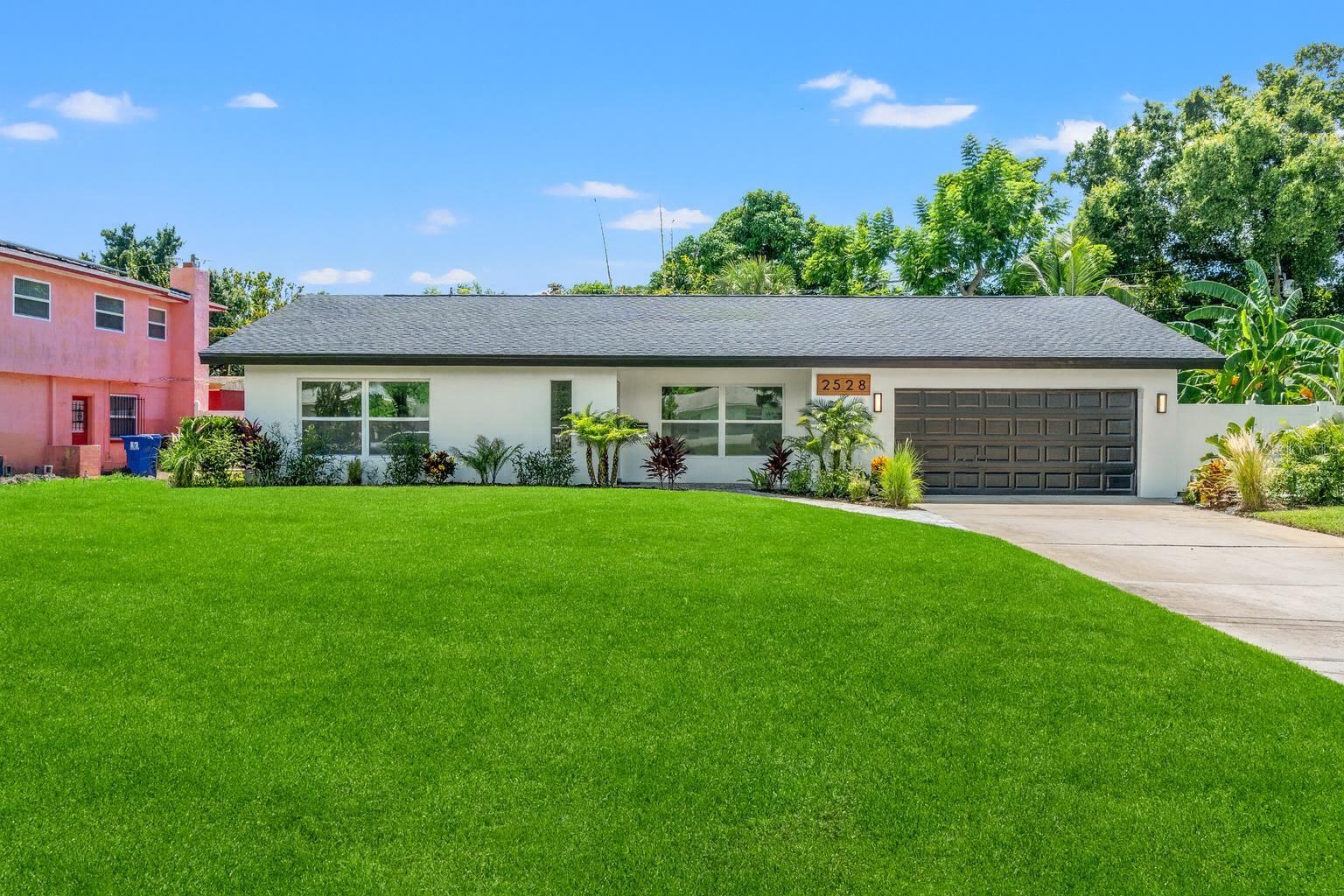 Welcome to your dream home in the highly desirable Lakewood Estates neighborhood of St. Petersburg. This fully renovated residence blends timeless design with modern comfort, offering peace of mind with a brand-new roof, impact windows, and a non-flood zone location. Inside, the home showcases an open, inviting floor plan with new tile flooring throughout, solid core doors, moldings, recessed lighting, and thoughtful custom finishes. The spacious living room features a new electric fireplace with custom shelving, while the dining area is enhanced by a striking feature wall that adds character and warmth. The gourmet kitchen has been completely reimagined with soft-close cabinetry, quartz countertops, modern stainless steel appliances, a large pantry, and abundant counter space—perfect for both everyday living and entertaining. The primary suite was expanded to include a spa-inspired bathroom with an oversized dual-sink vanity, dual shower heads, new tile, and glass shower doors. Both additional bathrooms have also been gutted and rebuilt with stylish new finishes, creating a fresh, modern feel throughout. One of these bathrooms is contained within the front bedroom, giving the home an additional en-suite. Every detail of this home has been addressed, including a new HVAC system, new plumbing and water heater, and a 200-amp copper wiring electric service. The lanai has been renovated with new flooring and screening, complemented by fresh landscaping and new pavers at the front and side entrances. Outside, a fully fenced yard with vinyl privacy fencing and a sprinkler system provides convenience and peace of mind. The attached two-car garage offers even more, featuring an automatic door opener and an EV charger for your electric vehicle. This move-in-ready home truly checks every box—modern upgrades, thoughtful design, and a sought-after location. Positioned steps away from the recently renovated St Petersburg Country Club, and minutes from beaches and downtown St. Petersburg this home is the one you've been waiting for.