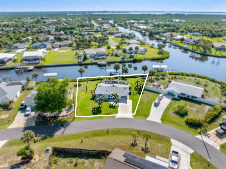 150 FEET OF WATERFRONT with QUICK access to open water! Live the ultimate Florida lifestyle in this move-in ready 2-bedroom, 2-bath waterfront pool home with direct canal access to Charlotte Harbor and the Gulf of Mexico. Boating enthusiasts will love the private dock with water & electric and covered boat lift, making it easy to get out on the water anytime.  From the moment you walk in, you’re greeted by gorgeous water views, setting the tone for this coastal retreat.  Situated on a fantastic oversized lot with a fenced backyard, this property offers privacy and space to enjoy your own special oasis.  The kitchen features newer cabinets and countertops, and a double slider to the lanai, creating the ultimate indoor-outdoor flow for entertaining.  Step outside to your large screened-in pool area, complete with two separate seating areas—perfect for relaxing or hosting guests. Beautiful tropical landscaping surrounds the space, offering privacy while you enjoy the pool. The pool was fully restored in 2024, and the roll-down storm shutters provide shade from the sun or added security when away.  The meticulously maintained backyard has lush Bimini Bermuda grass that leads to your private dock—ideal for evening “docktails,” fishing, or simply soaking in the waterfront lifestyle.  Extensive updates include, (2019) HVAC, (2021) fenced back yard, (2022) irrigation system, boat lift cover, (2023) roof, pool cage, pool restoration, pool heater, roll-down storm shutters, updated bathrooms, (2024) pool pump, water heater, Maytag washer & dryer, Whirlpool kitchen appliances, impact garage door, dock electrical rewired, interior & exterior paint, HVAC UV light & coil cleaning and in (2026) new attic insulation.  This home has impact windows for added peace of mind.  Thoughtfully upgraded, this home is the perfect blend of comfort, privacy, and true Florida waterfront living.  Schedule your showing today and start living your coastal dream!