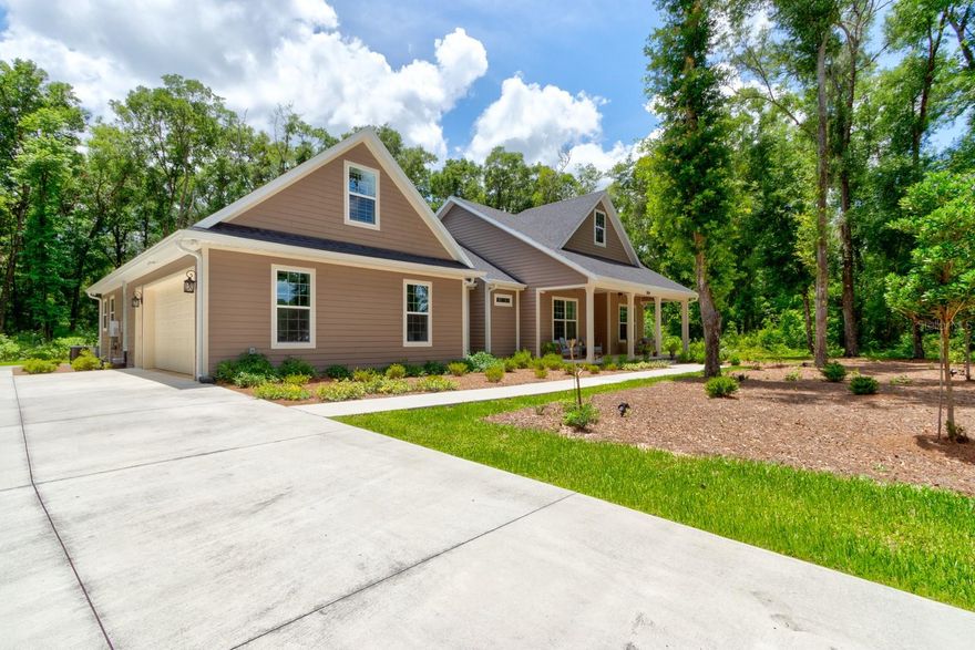 One or more photo(s) has been virtually staged. Welcome to 3504 Dunstable Drive in Glenwood Reserve, a custom 2024-built home that feels less like typical newer construction and more like a private retreat designed with real life in mind. Set on over an acre with a natural wooded conservation/preserve backdrop, this 4-bedroom, 3.5-bath home gives buyers the space, privacy, flexibility, and quality that are increasingly hard to find at this price point. From the rocking-chair front porch to the long driveway, mature trees, and quiet cul-de-sac setting, the arrival immediately feels calm, private, and set apart. Inside, the home opens with warmth and polish rather than the cold, cookie-cutter feel found in many newer homes. Bamboo flooring, 10-foot ceilings, 8-foot doors, plantation shutters, custom trim work, and a thoughtfully designed floor plan create a sense of quality throughout. The main living area is centered around a double-sided gas fireplace, connecting the great room to the rear outdoor living space and giving the home a natural gathering point for relaxing evenings, family time, or entertaining. The kitchen sits at the heart of the home with granite countertops, shaker soft-close cabinetry, gas cooking, stainless steel appliances, double oven, dedicated pantry space, and a coffee station/butler’s pantry area that adds both function and everyday convenience. The layout is one of the home’s strongest advantages. The primary suite is privately positioned with dual vanities, his-and-hers closets, a private commode area, walk-in shower, and a comfortable retreat-like feel. On the main level, two additional bedrooms provide excellent flexibility, including a standout private guest wing where one bedroom connects to a kitchenette/flex space with its own exterior access to the screened porch. That space gives the home rare versatility for extended guests, in-law-style use, a private office, hobby space, or simply a separate retreat within the home. Upstairs, the fourth bedroom/flex suite includes a window, dedicated mini-split A/C, and attached half bath, making it ideal for guests, media, office, fitness, recreation, or a private teen/bonus space. The home also offers the practical upgrades buyers appreciate after they move in, including no-step showers, water purification, tankless water heater, gas appliances, spray foam insulation, block and Hardie board construction, gutters with guards, motion sensor lighting, and ceiling fans throughout. The oversized garage is another major selling point, offering epoxy-style flooring, wash sink, windows, a higher-clearance hurricane-rated garage door, and room for larger vehicles or trucks. Outside, the screened rear porch, outdoor shower, wide rear sidewalk access, and peaceful wooded backdrop make the property feel connected to nature without giving up convenience. Glenwood Reserve is known for spacious one-acre homesites and a quiet low-density setting while remaining convenient to DeLand shopping, dining, schools, parks, downtown, and major routes. If you have been waiting for a newer custom home with privacy, quality construction, flexible living spaces, and a setting that truly feels special, this property deserves to be seen in person. Dining room chandeliers do not convey.