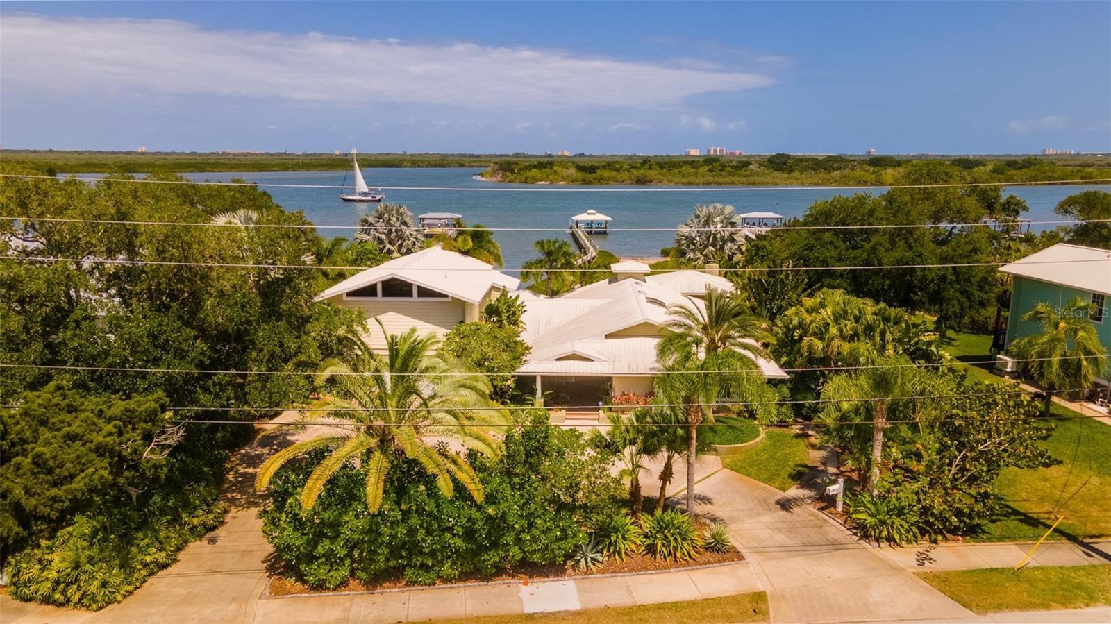 Custom Intracoastal 4 bedroom, 4.5 bath residence with fabulous pool, lanai and dock. Situated on almost half an acre, this property offers an amazing amount of privacy with stunning views. Ideal floorplan features master suites both upstairs and down. Another suite has sitting room and separate entrance and makes ideal in-law quarters. The kitchen is built for entertaining with large bar and large island providing lots of room for family and friends to gather. Stainless appliances, beautiful Cherry cabinetry, gleaming granite and tons of cabinet and counter space plus a perfectly situated butler’s pantry and laundry make multi-taking and organizing a breeze. The cozy family room with natural gas fireplace overlooks the lanai. The master suite has cathedral beamed ceilings, private riverfront balcony and marble bathroom with whirlpool tub. The downstairs suite overlooks a peaceful tidal cove. Travertine floors and Ipé decking. Jeldwynn impact windows, sliders, french doors and beautiful custom woodwork throughout. The covered lanai with wood-burning fireplace and summer kitchen overlook the resort-like gas heated salt pool and spa with private pool bath and changing room. Natural gas for tankless water heater, 16000kw generator, stove and summer kitchen. Covered dock with lift. Furniture negotiable. Note: A small portion of the home was existing in 1986 and was completely renovated in 2007 along with new additions & a second story.