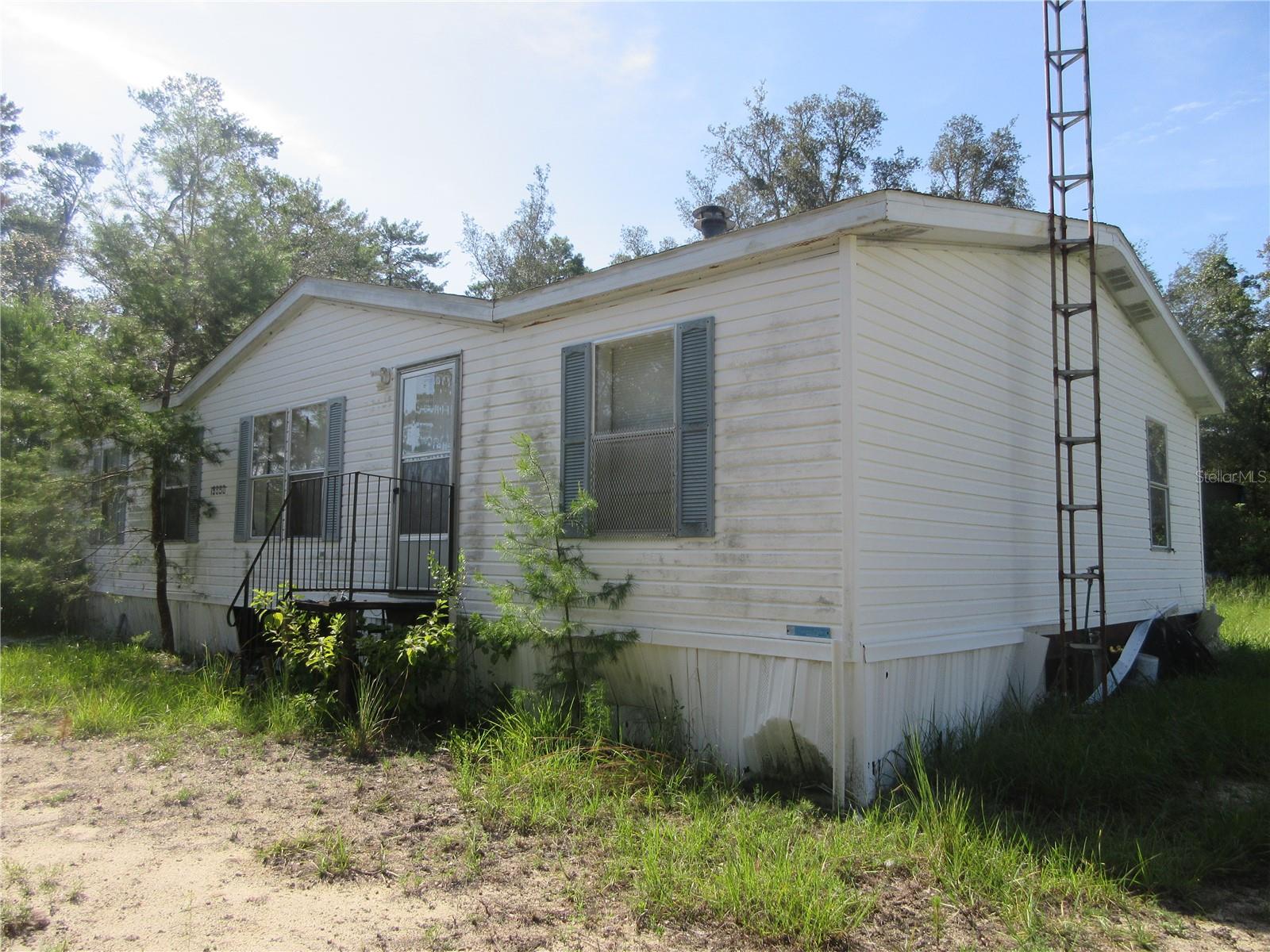 Extremely rare property! This property actually touches and adjoins the Ocala National Forest, which gives you permanent privacy and endless outdoor fun and activities! If you want to get away from city life and live on the literal frontier at an affordable price, this is it! No HOA. No fees of any kind. This property is two lots totaling 48 of an acre. It has its own well, septic tank, powerpole, and a 9x20 container shed. There is also a dilapidated 1998 3/2 27x48 Homes of Merit double wide mobile home on it which is of little or no value due to the fact the roof has collapsed on half the home. However, the floors seem to be solid. You could repair the home or pull it off the property and bring in a new replacement home, your choice. Either way, it's a great property. The as long price is just $80,000. Also listed for sale is the adjoining property. The MLS number is OM706647, address 15960 NE 231st ST, Ft. McCoy, Florida 32134-3356. Please review it also. If you purchase both 15990 and 15960, it will give you almost a full-acre front on the Ocala National Forest. 15960 also has a livable 2005 24x40 2/2 Nobility double-wide mobile home and shed. The asking price on 15960 is also $80,000. So buy one or get both and start enjoying the great outdoors. Hurry!