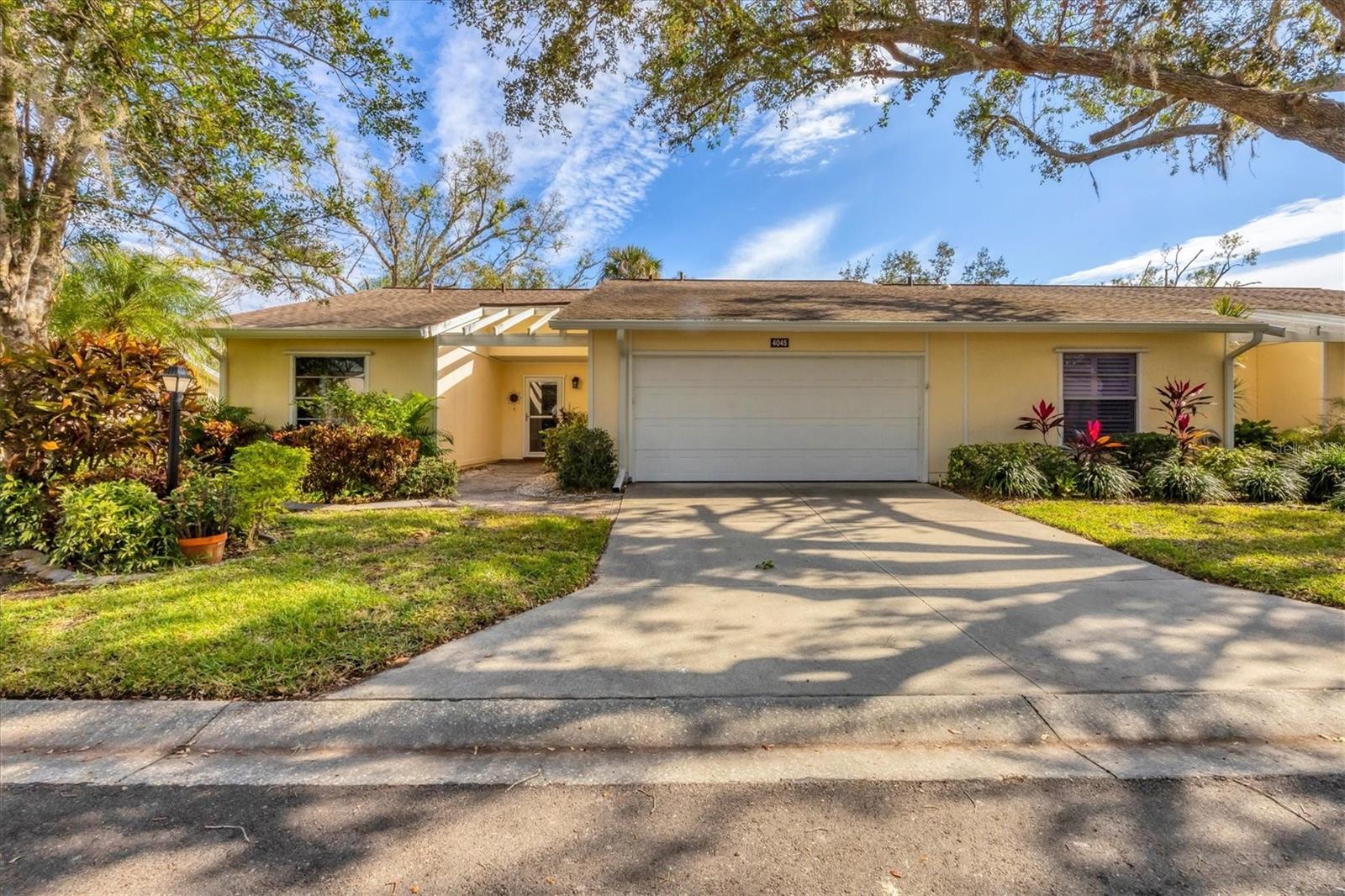 SPACIOUS, UPGRADED, METICULOUSLY MAINTAINED, 2 BEDROOM/2 BATHROOM/2 CAR GARAGE VILLA! Located in desirable Oakhurst. From the moment you step inside, you will experience the tasteful design, the attention to detail, and feel the warmth of a comfortable yet elegant home. The spacious living and dining area is ideal for relaxing or entertaining. The updated kitchen offers an eat-in area and also opens to a fabulous BONUS ROOM. You may never want to leave this inviting Florida room, with its peaceful green views. The generous sized 2 car garage includes washer and dryer. The most recent updates are brand new downspouts and gutter, complete with "leaf guard". Whether this is your new full-time residence or your winter getaway in the sun, it is definitely move-in ready! Oakhurst is a lovely, canopy-treed neighborhood, an active 55+ community whose residents enjoy amenities that include a heated pool and welcoming clubhouse with ongoing social events. Cable TV, INTERNET, the roof, pest control, exterior maintenance, and landscaping are ALL INCLUDED in the condo fee. Imagine your maintenance-free lifestyle, in sunny Sarasota, in a truly charming home.