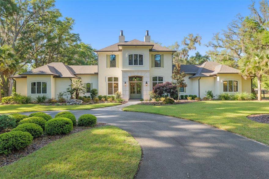 Epitomizing French Country architecture this absolutely stunning, chateau-inspired estate home is situated on a secluded 1.38 acre fully fenced lot with private gate. Exceptionally designed with spectacular finishes inside and out, this Bullard built, breathtaking home spans nearly 4200 SF under air. Featuring 3 bedrooms, 2 separate home offices, a home gym/playroom and 4 full baths, its floor plan flaunts an easy flow for daily living and formal entertaining. The private electric gate opens onto the home’s circular drive for guests, and the owner’s driveway to the left for accessing the split garages: on the left, the 1-car carriage garage, and a 2-car garage on the right. Characterized by its steep pitched gabled roof, tall doors, arched windows, stucco exterior with “ArchusStone” lime rock coating, decorative upper story shutters and twin chimneys, this home embellishes the trademark detail of French Country architecture – symmetry. The double French entry doors open onto the gracious foyer, noted with dark French oak flooring which connects the downstairs living spaces.  To the left is formal dining room. To the right is the radius staircase. The family room has a tray tongue-n-groove ceiling accented with white beams, and two sets of French doors that open onto the screened lanai offering direct views of the private rear yard and trees beyond. The fireplace hood is similar in style to the kitchen custom vent exhaust hood. The Chef’s kitchen is truly spectacular. Featuring DH custom crafted cabinets topped with quartzite counters, no expense was spared. Appliances include a 48” sub-zero refrigerator with matching front cabinet panels, a 48” Wolf duel fuel range, a warming drawer and a microwave drawer. Between the kitchen and the breakfast nook is a walk-in pantry with wood shelving. Off the nook is the day foyer with stop-n-drop zone, and a French door that connects the breezeway for covered access to the 350 SF 1-car carriage garage. Opposite the nook side of the kitchen is the separate drop zone room with a coat closet, add’l cabinetry and shelving for storage, and direct access to the attached 675 SF 2-car garage. Past the drop zone is the scullery, and one of the prettiest overflow kitchens you will see, complete with wine cooler, sink with disposal, and 3 wine drawers. Next to the staircase is the master wing of the home complete with separate office with gas fireplace, custom built-ins, and a coffered ceiling; a guest hallway bath with shower, a proper-sized laundry room, and the master suite. The master spa bath has dual vanities, a slipper tub, 2 fit-and-finish organizational system walk-in closets, and a closet pocket door to directly access the laundry room. Upstairs are the two en suite guest bedrooms, the second home office space, and a separate gym/playroom. The 516 SF screened lanai spans nearly the width of the home, and has a summer kitchen with grill hood and prep sink. The list of luxury attributes and custom details is lengthy: custom drapery, Plantation shutters, Quartzite and granite counters, several interior storage closets, solid core doors for all bedrooms, baths, and pocket doors, 2 gas fireplaces, a Cummins generator, landscape lighting, a 2023 H2O filtration system, 2 gas tankless water heaters, a 3-zone HVAC system, epoxy finished garage floors, post-tension slab, Icynene insulation, R13 blown cellulous wall insulation and security system with surveillance cameras. Clay Electric for utilities. No HOA.