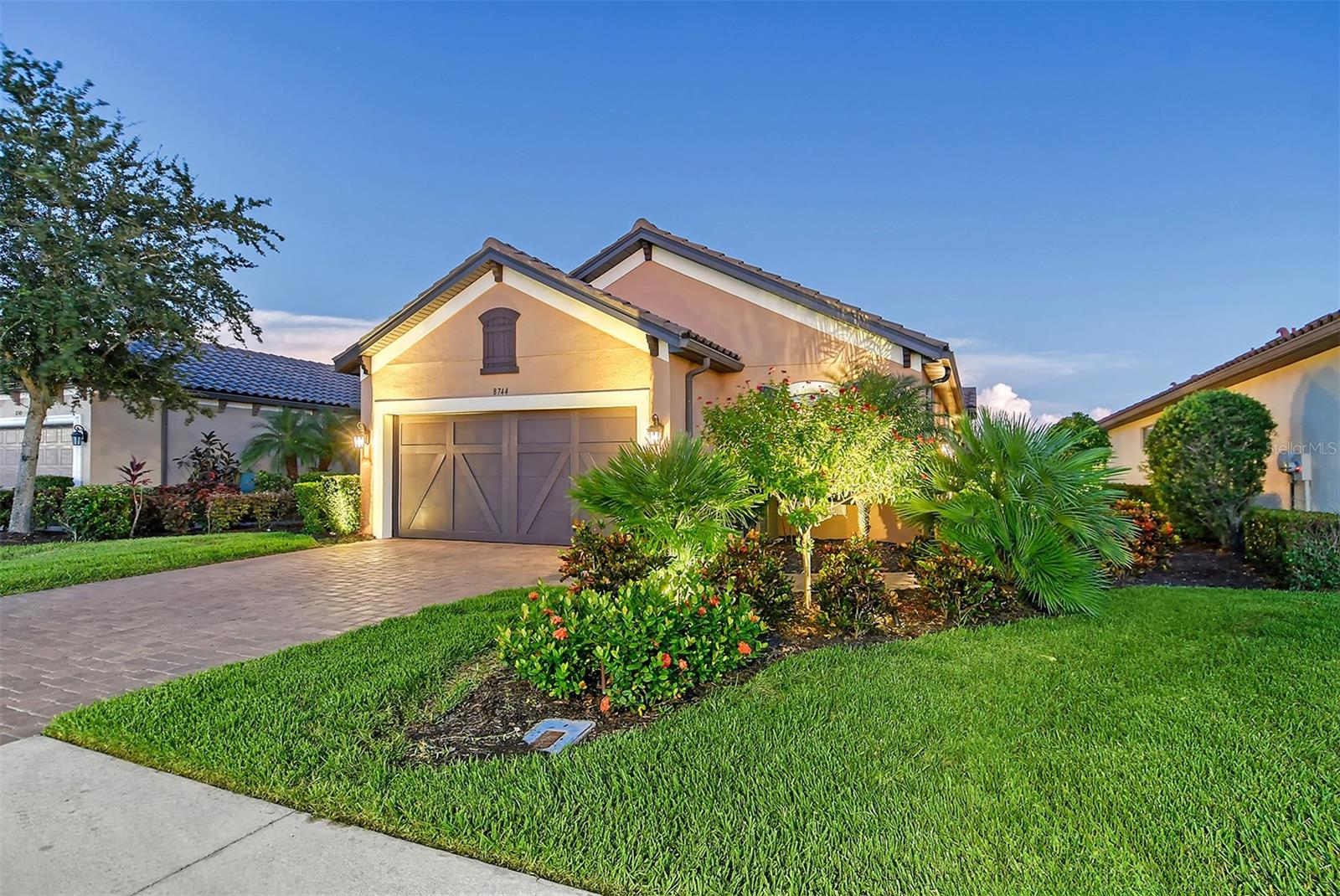 Welcome to your dream oasis in Palmer Ranch’s gated community of Cobblestone! This exquisite home, built by Taylor Morrison in 2018, masterfully blends luxury and functionality at every corner. Offering a maintenance-free lifestyle, the Arezzo floor plan with Elevation B spans 1,917 square feet of meticulously crafted space, with over $50,000 in premium upgrades. This three-bedroom, two-bath residence also includes a versatile den or office space. The home features 20-by-20-inch Level 4 floor tile throughout, crowned by elegant molding in every room. With 8-foot doorways and recessed lighting in the den, primary bedroom, bath and great room, the interior exudes a seamless blend of comfort and sophistication. Designed for safety and peace of mind, the home includes hurricane-impact windows and a reinforced garage door, ensuring protection in any weather. The heart of the home is its expansive living room, which opens to a stunning 30-by-300-foot lanai adorned with travertine tile and a summer kitchen, ideal for entertaining. The outdoor space features a paver walkway, an island grill with granite countertops, a sink and a gas rotisserie grill. No-see-um protective screening and outdoor landscape lighting enhance the ambiance, while extra outlets inside and out make hosting effortless. Inside, luxurious details abound, including tray ceilings, 5-inch baseboards, quartz Cambria countertops in the gourmet kitchen, Level 5 cabinetry and top-of-the-line GE Café appliances, including a natural gas range. The primary suite is an elegant retreat, featuring tray ceilings, darkening shades, dual sinks, quartz countertops and a frameless glass walk-in shower with a full bench. The en-suite second bedroom offers granite countertops and a tub, providing a spa-like experience for guests. For added convenience, the laundry room is outfitted with GE appliances, a Corian folding surface, and abundant 42-inch cabinetry with a ceramic under-mount sink. The garage boasts epoxy floors and ample rack storage for vehicles and more. The home is further equipped with a whole-house surge protector, tankless gas water heater and 220 AMP service, while recent exterior upgrades include fresh paint and gutter guards. Cobblestone’s resort-style amenities and proximity to Legacy Trailhead access provide endless opportunities for recreation. Just a short drive from the sugar-white sands of Siesta Key Beach, this meticulously maintained home offers the ultimate Florida lifestyle. Schedule your showing today and make your Florida dream a reality!
