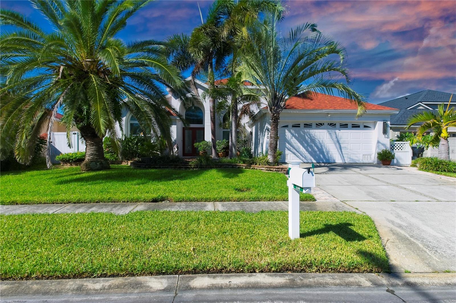 Fantastic curb appeal greets you as you arrive at this lushly landscaped lakefront home in the desirable, quiet neighborhood of Brighton Bay. Entering through the double entry doors into the foyer, you will immediately experience the light, bright feeling created by soaring vaulted ceilings throughout, large open rooms and the peaceful waterfront view. The beautifully functional modern kitchen features quartz counter tops, a breakfast bar, plenty of storage space. Split floor plan. The covered, screened lanai will be your charming oasis, looking out onto the beautifully landscaped backyard and a picturesque lake teeming with aquatic life, bird life and saw grass. Dozens of fruit trees dot the property including lemons, mangoes, figs, avocados and many more. Upgrades/Extras include new engineered wood floors in the study and bedroom 3, crown molding, an interior utility room, a central vacuum system, custom made hurricane protection for all windows, accent lighting on plant shelves, and ceiling fans throughout. This beautiful home is conveniently situated close to St Pete/Clearwater Airport, Tampa Airport and downtown St. Pete. All room dimensions are approximate. Buyer to verify. (some photos digitally enhanced)