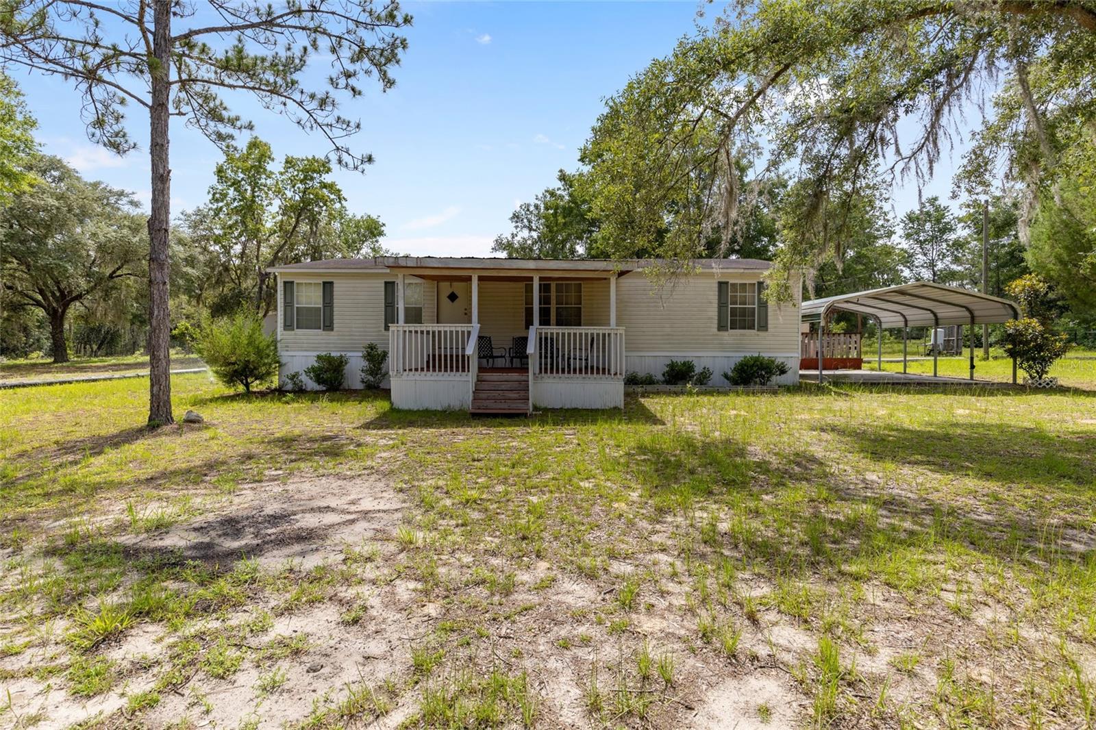 Welcome to this spacious 4-bedroom, 2-bathroom double-wide mobile home located in the peaceful Forest Park neighborhood of Bronson, FL. Situated on a generous 1.25-acre lot, this 1,976 sq. ft. home offers the perfect blend of privacy, comfort, and functionality.
Inside, you’ll find cathedral ceilings that create a bright and airy feel, along with a well-designed split floorplan that offers space for the whole family. Enjoy both a front and rear porch, ideal for morning coffee or relaxing evenings outdoors. A cozy firepit area adds even more charm for entertaining or enjoying quiet nights under the stars.
The property includes a carport for covered parking, a storage shed, and is equipped with well and septic, giving you added independence and lower utility costs. Whether you’re looking for a quiet retreat or room to grow, this property offers the space and flexibility to make it your own. The seller is also willing to replace roof once property is under contract.
Don’t miss this rare opportunity to own over an acre in Forest Park—schedule your private tour today!