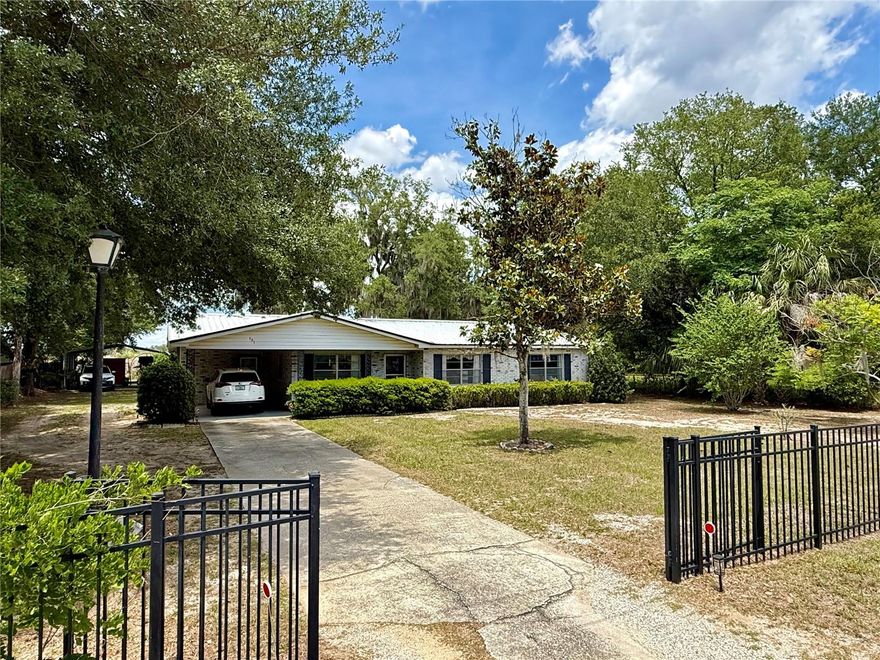 Welcome to this one-owner, lovingly cared-for 3-bedroom, 2-bath home that blends comfort, space, and versatility. Filled with years of cherished memories, this home is ready for its next chapter with new owners. The generously sized bedrooms provide plenty of room for family living. The primary bathroom features a walk-in shower, while the guest bathroom offers a tub/shower combination and an extra-wide doorway for wheelchair accessibility. The home also includes an indoor laundry room with additional storage and a kitchen pantry for added convenience. Constructed with concrete block and topped with a metal roof for long-lasting durability and peace of mind. Outside, enjoy a fully fenced yard ideal for pets, play, or privacy. The property is well-equipped for those needing extra parking or workspace, featuring an attached 1-car carport, a separate 2-car carport, a storage shed, and a spacious 36 x 36 metal building. Perfect for hobbyists, mechanics, or anyone needing room for projects, the building also includes a climate-controlled office or den—great for a remote workspace, hobby room, or retreat. With plumbing and electrical already in place, there is potential to add a kitchenette and bathroom with ease. This well-maintained property offers endless possibilities for living, working, and enjoying your space. Come see all it has to offer!