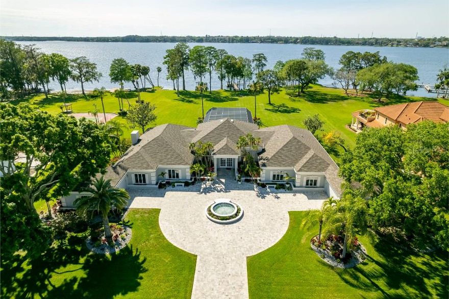 Magnificent Waterfront Smart Home located in the Gated & Guarded community of Chateaux Des Lacs on Lake Tarpon. This Luxurious & Rare property is 1.97 Acres with unobstructed water views, breathtaking sunsets, and includes its own Private Dock. Massive entry with 18 Ft Ceilings, amazing water view, Italian rectified tile floors, large Palladium windows, and energy efficient insulated French doors. This beautiful home is built for entertaining. Screened lanai with granite poolside wet bar overlooking enormous pool w/ spillover spa, and room for well over a hundred guests. Chef’s Dream Kitchen with stainless steel appliances, granite counters, warming drawers, wood cabinetry w/ glass front lighted display area, spacious breakfast nook dining room. Electric Fireplaces in the Family Room and Great Room. The Master Suite has a water view plus an attached room for an office or entertainment area. Luxurious Master Bath with Steam Shower and Jetted Tub. Circular driveway & enormous travertine courtyard w/ fountain, a soaring covered porch. Your Vehicles will be right at home in the huge 4 Car Garage spaces (2 Cars On Each Side) One Garage is finished with Mirrors and A/C and is perfect for an exercise room. Recently updated, must see. This is an amazing home with amazing views. Spend the day boating/skiing on Lake Tarpon or just relaxing poolside. Be sure to check out the Matterport virtual tour.