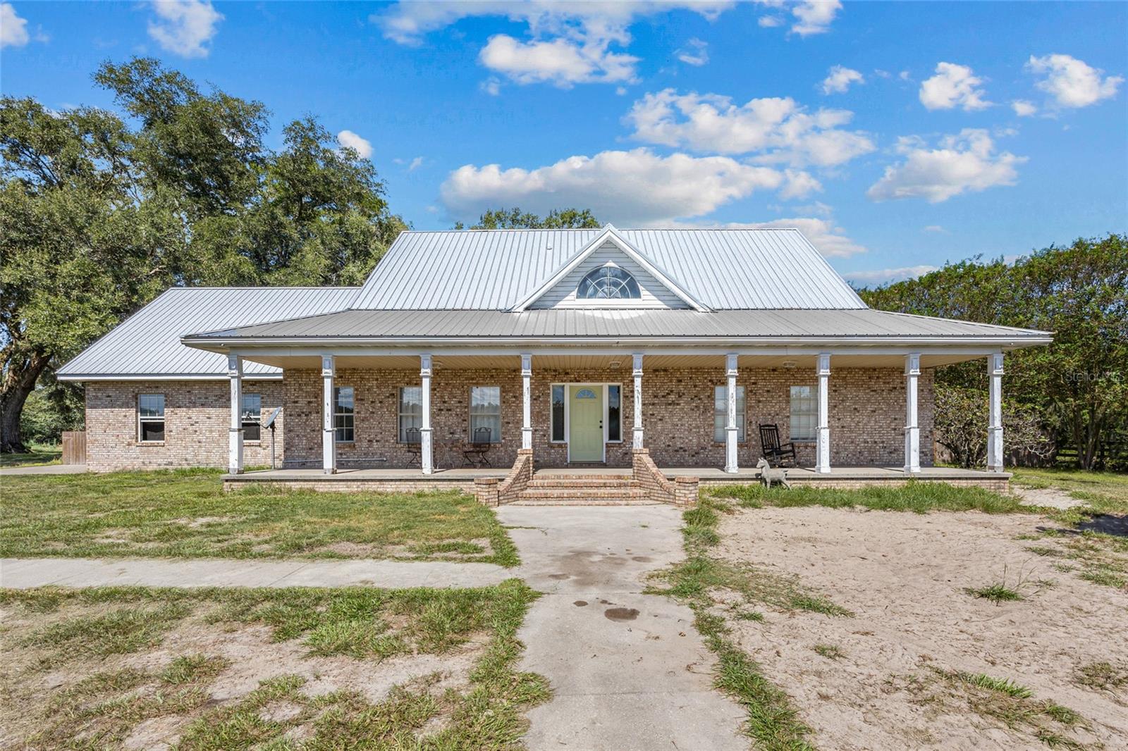 Stunning horse property, complete with an in-ground swimming pool and 2,836 sq ft 4-bed, 3-bath plus bonus room home on 10 acres in Lake City! Southern charm awaits as you approach the 2-story brick home with covered front porch and 2022 metal roof. Indoors a grand foyer connects to the living room that features laminate wood flooring. To the right of the living room are the two first floor bedrooms. The huge updated primary bedroom boasts an upscale ensuite with walk-in closet, double sinks, and walk-in shower. The sizable guest room also has a large walk-in closet. Off the living room, the expansive screened porch provides a welcoming sanctuary for relaxing, entertaining, or enjoying the shade after a refreshing dip in the salt water pool. Opening to the living room is the spacious eat-in kitchen featuring a lovely breakfast nook with bay window, stainless steel appliances, and entry to an enclosed room that would be ideal as an office or formal dining room. Rounding out the first floor is a full guest bath, laundry room, and storage closet under the back stairs that lead to the oversized bonus room/attic. To the right of the main entry foyer is the stairway that ascends to the two second floor guest rooms with double closets, and full guest bath with double sinks and tub/shower combo. Outdoors you will find a privacy fence for the swimming pool, two storage sheds, a pond, and a variety of trees, including mature oaks, 50 mature crepe myrtles, 5 chestnut trees, and 2 producing fig trees. The property’s extensive fencing and cross-fencing cover over 3/4 of the land, creating four separate pastures and a large, secure environment. There's also a five-stall pole barn, making it an ideal setup for horses. Adding additional curb appeal to this serene property is the side-entry 2-car garage. Situated on a private road with only 4 other homes on 10 acres each, the neighborhood is quiet and quaint, with no HOA. Deer and wild turkey are frequent guests. The property is conveniently located southwest of Lake City. The Lake City Mall, HCA Florida Lake City Hospital, and the Lake City Commons, with Publix, CVS and The Home Depot, are all within 9 miles. Just a short drive away, you’ll find breathtaking state parks, including Ichetucknee Springs, O’Leno State Park, and Alligator Lake Park, a 1,000-acre recreation area that includes a playground, canoe launch, trails, and picnic shelters. This property has it all! It just needs a bit of TLC to bring it back to its prime. Schedule your private showing today and step into a world where your personal touch brings new life to this majestic home, your horses have room to roam, your family has space to grow, and every day feels like a vacation!