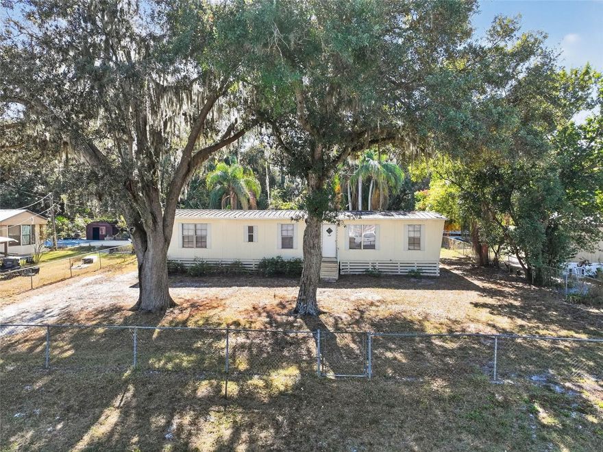 One or more photo(s) has been virtually staged. NEEDING 4 BEDROOMS, A PLACE FOR PETS, A GARDEN, VEHICLES AND STORAGE?  This 4 BR/2BA mfg home is move in ready with NO HOA, a fenced yard, a storage building, and no rear neighbors. Have "country living" but in a convenient location just off Thornhill Rd and close to the Polk Parkway.  The island kitchen has updated cabinets and an adjacent nice sized dining area. The primary bedroom is large with a walk in closet and en suite bathroom. No carpet for easy maintenance!  Under the covered open back porch is an attached storage room with laundry hook ups. A separate storage building is in the backyard along with ample room for activities.  This would also be a great property to add to an investment portfolio.