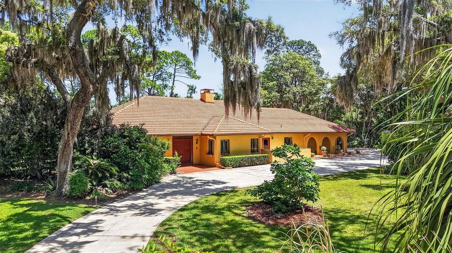 One-of-a-kind Mediterranean-style estate on a private 1-acre homesite in the desirable Elysium community of Mount Dora, 4 bedroom 3.5 bath with no rear neighbors and peaceful conservation views, brick paver entrance, circular driveway and expansive parking create a grand arrival, tiled roof adds to the timeless design. Double door entry opens to wood flooring, large windows, beautiful archways and architectural details that add character throughout. The formal living/dining room features soaring ceilings with tile flooring and an open concept layout offering multiple seating areas filled with natural light. The living room showcases a wood-burning fireplace, built-in cabinets, and access to the pool area. A half-bathroom for guests is accessed from the hallway. A generous family room with plantation shutters adjoins the warm and inviting kitchen with wood cabinetry and glass accents, spacious wrap-around layout offering abundant prep and storage, granite countertops, tile backsplash, a large farmhouse sink centered under a window with plantation shutters, recessed lighting, double ovens, pendant lighting over the breakfast bar, a large breakfast area and a large indoor utility room. Solar glass sliders in the breakfast area enhance natural light and open onto the inviting front patio which offers the perfect spot for outdoor dining with a spacious concrete deck and peaceful views. The split floor plan has 2 bedrooms connected by a Jack-and-Jill bath. There is an additional bedroom with neighboring 3 piece bathroom that is suitable for private guest or in-law quarters with private entrance. The primary suite is a true retreat with 2 walk-in closets and has direct access via solar glass sliders to the private walled veranda/courtyard and to the pool. The spa-like primary ensuite bathroom with dual sinks, updated lighting, walk-in shower showcasing clean subway tile with built-in niche, and a separate soaking tub perfectly positioned beneath the window with peaceful courtyard views creating a relaxing retreat. The courtyard offers relaxed outdoor living with brick pavers and a peaceful Mediterranean-inspired feel, intimate seating area perfect for morning coffee. Lush greenery and mature trees beyond the walls create a serene garden-like backdrop, The home offers resort-style outdoor living with an expansive screened-in salt water pool and oversized deck, covered lanai with beautiful wood-paneled ceiling, ceiling fans, and arched openings. Just beyond, a private garden with mature trees enhances the serene tucked-away feeling. Vibrant landscaping includes mature fig, avocado, pineapple, and blueberry trees. Major updates include exterior paint 2024, roof improvements with valleys and ridges redone over the past 4 years and roof coated 2024, septic field replaced 2024, paid-off solar system. Located in a charming peaceful community less than 2 miles from historic downtown Mount Dora with boutique shopping, dining, and waterfront charm, this is a rare opportunity to own a private estate in one of Central Florida’s most desirable areas