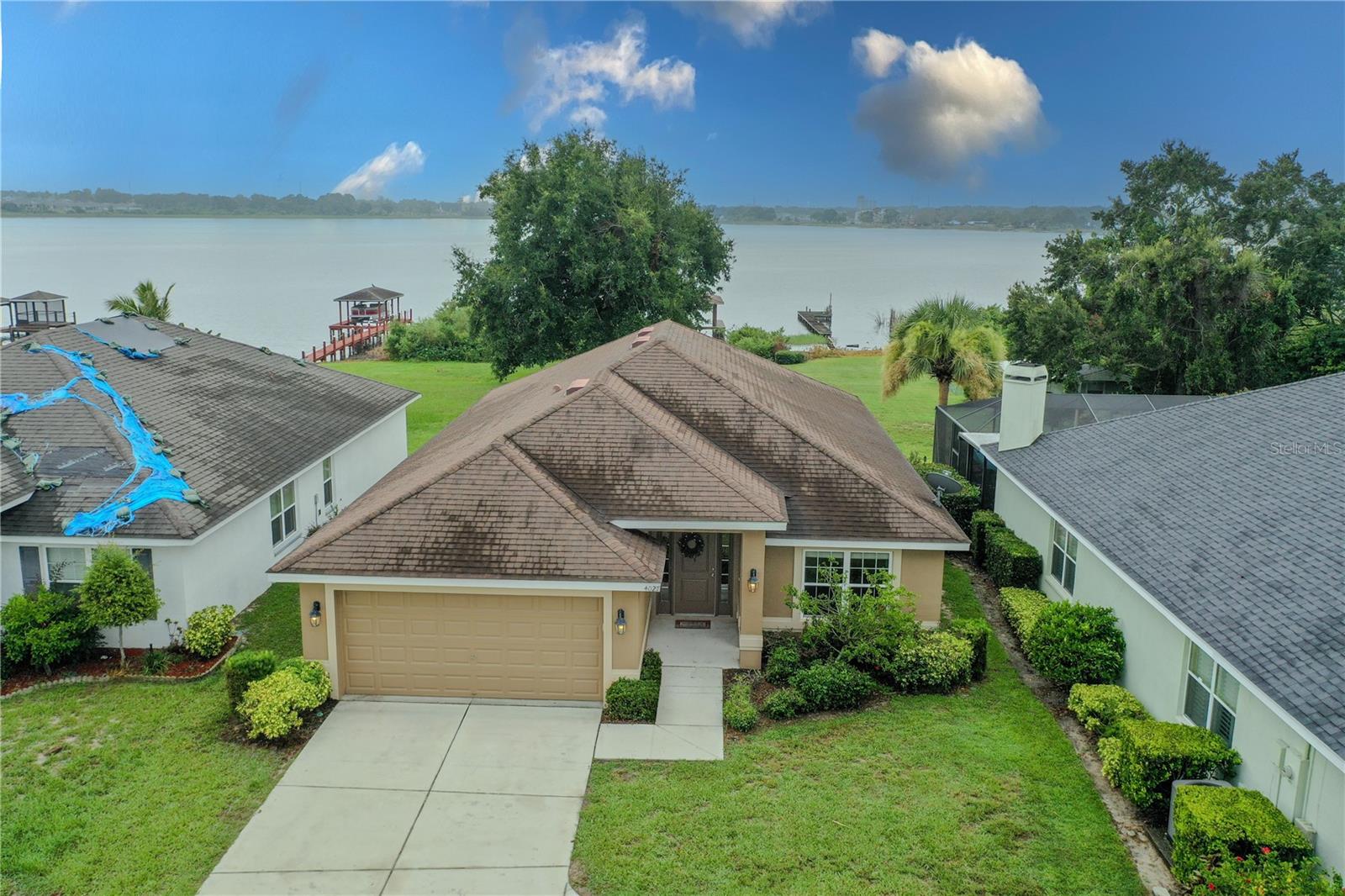 One or more photo(s) has been virtually staged. Welcome to your dream lakefront retreat on the Chain of Lakes. Situated on the picturesque shores of Lake Conine, this property offers direct access to the extensive canal system of the Chain of Lakes, opening up endless opportunities for fishing, boating, water skiing, paddleboarding, and canoeing. Imagine spending your days on the water, enjoying all the recreational activities this vibrant location has to offer. This stunning four-bedroom, two-bathroom home boasts a bright and well-maintained interior, designed for both comfort and style. The open-concept layout seamlessly connects living spaces, perfect for entertaining and family gatherings, while the thoughtfully arranged split bedroom design ensures privacy for everyone. As you step inside, you will appreciate the luxury vinyl flooring that flows throughout, complemented by elegant tile accents in the kitchen and bathrooms. Natural light pours in through the windows, creating an inviting atmosphere throughout the home. The highlight of this property is the large covered dock equipped with a boat hoist, providing a perfect spot to launch your aquatic adventures. In addition to the serene lakefront lifestyle, you will find yourself conveniently close to a variety of amenities, including restaurants, shopping, and theme parks, making this home not only a tranquil oasis but also a hub of excitement. Don’t miss your chance to experience the best of lake living in this exceptional home.