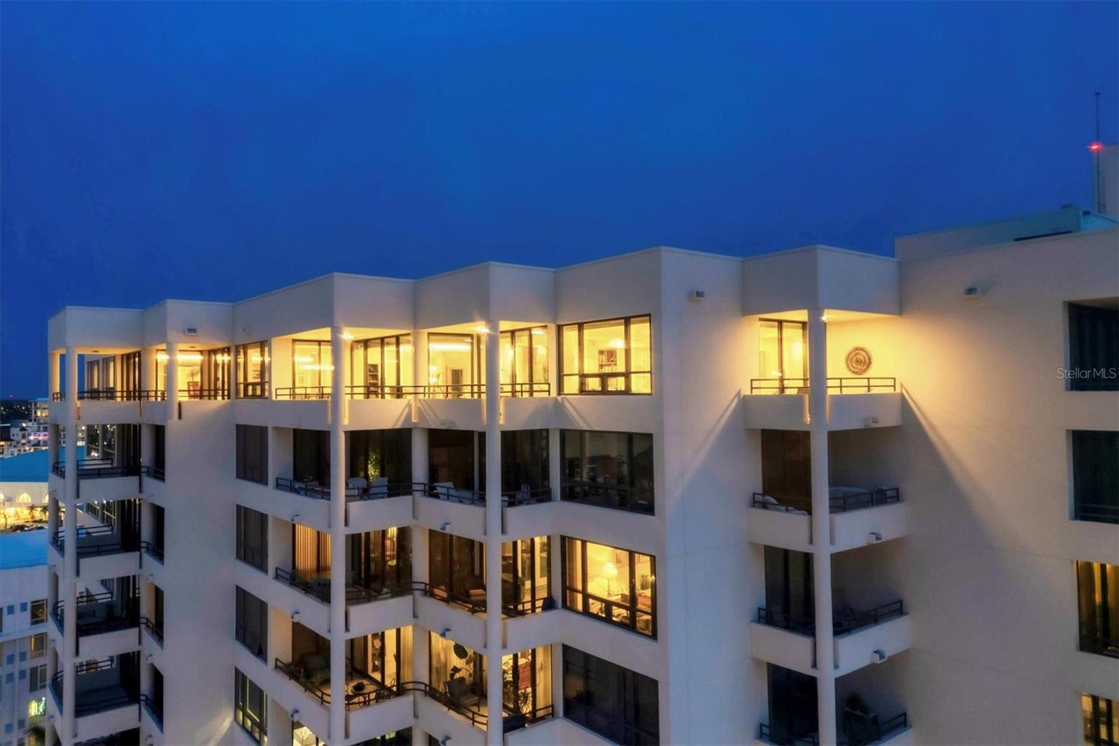Sophisticated Penthouse with Panoramic Bay and City Views in Downtown Sarasota
Discover refined living in this fully renovated, architect-designed penthouse, located in the heart of Sarasota’s cultural district. Offered fully furnished, excluding art and sculptures, this residence masterfully blends mid-century modern architecture with contemporary design. Conceived by acclaimed architect Bill Niblock, the home features an open floor plan that seamlessly connects expansive living, dining and kitchen spaces.
Seven wraparound balconies capture sweeping vistas of the Sarasota skyline and Bay, offering exceptional indoor-outdoor flow for both intimate gatherings and grand-scale entertaining. Renovated in 2019 and thoughtfully enhanced in 2024, the residence meets rigorous modern standards with impact-rated, floor-to-ceiling sliding glass doors and windows compliant with Miami-Dade HVHZ regulations.
Modern infrastructure includes a 200-amp electrical panel, high-efficiency HVAC, an 85-gallon commercial-grade water system and a manifold-based PEX plumbing design for enhanced durability. At its center, the Studio Becker-designed kitchen features Sub-Zero and Miele appliances, custom cabinetry and sleek blue granite surfaces.
Adjacent, a dedicated media room showcases an 85-inch television, an 11-speaker ATMOS sound system and custom walnut cabinetry. The owner’s suite offers two private balconies, three walk-in closets, an 85-inch television, and a spa-quality bath with dual rain showers and limestone sinks.
Smart home systems are integrated throughout, including motorized Hunter Douglas shades, Wi-Fi-enabled Haiku ceiling fans, CAT-6 cabling, USB charging outlets and a WaterCop leak detection system. Finishes include 32-by-32-inch imported porcelain tile flooring, flush Italian doors, an Artwall hanging system and LED recessed lighting.
Situated in Bay Plaza, residents benefit from 24-hour concierge and valet services, a heated pool, a fitness center and direct access to Sarasota’s acclaimed arts and dining venues. Three deeded parking spaces and EV charging stations enhance convenience. This penthouse offers an effortless lifestyle defined by architectural pedigree, sophisticated amenities and premier location.