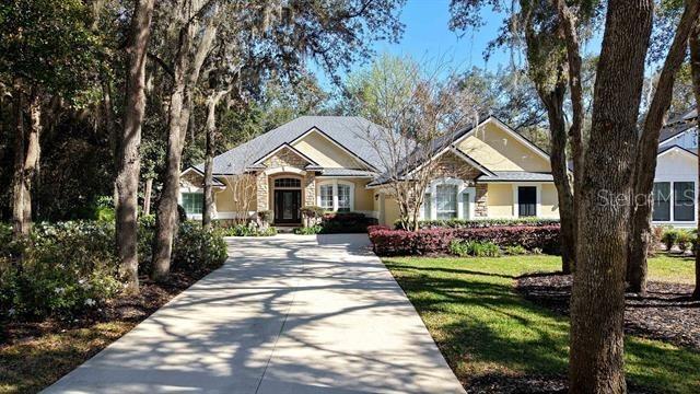**This motivated seller said to reduce listing another $10,000 for a total price reduction on this lovely house for a total of $120K!!** This Gem is located on a beautiful, wooded lot within the Oak Grove neighborhood in the King and The Bear w/24-7 gated security subdivision. It boasts 5" plank wood flooring, Quartz Cambria Counter tops in kitchen and Bath and so much more! This well laid out floor plan offers 4 spacious bedrooms, 3 full baths, an oversized side entry 2 car garage are just a few of the treasures in this home. The home has a NEW roof, heated, screened pool (w/LED pool lighting) area and NEW Pool Pump, NEW Cool deck is a few of the other options this lovely home offers. Private Owners suite with blackout Shades and Plantation Shutters offers you a peaceful soaking tub with a separate walk-in shower and dual oversized counter space. This Home also offers a Whole home water softener, full irrigation system, 2 HVAC units installed in 2019, New water heater 2020. Wired surround sound in Living room and Outdoor living space. The outdoor space is also wired for a TV setup. The private quarters upstairs is an oversized bedroom/office/playroom/den with a full bathroom which offers you the maximum in flex space. The spacious living area with fireplace and built in shelving is the perfect entertaining area right off the open kitchen with loads of counter space and cabinets. Two wall ovens for a concerning home cook to make the best of their time in the kitchen. Formal dining room with a Den and Breakfast Nook also just off the Kitchen! This spacious, comfortable home is just what you've been looking for!! Subdivision also offers, NO CDD FEES, Swimming pool, workout room, golf, basketball courts, pickle ball and tennis courts and more!