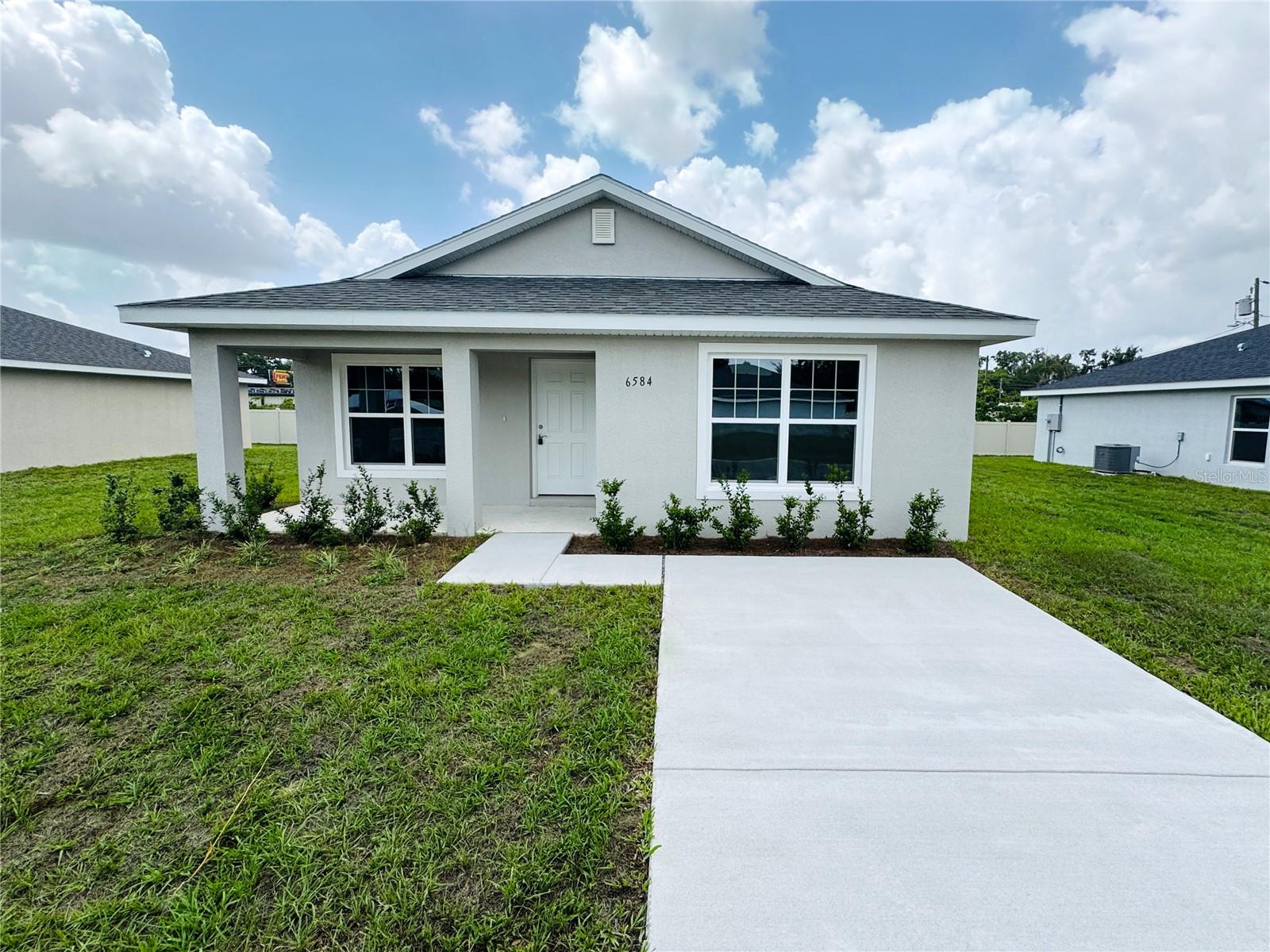 Discover this beautiful new construction home in the charming “Front Porch Community” of Belleview, Florida. This move-in-ready bungalow-style residence features luxury plank vinyl flooring throughout the unit. Enjoy an open-concept layout with a dining area, eat-in kitchen, and neutral finishes. The kitchen is equipped with shaker cabinets, stainless steel appliances, and light granite countertops. The primary bedroom includes a walk-in closet and a private bath with a vanity. Located just minutes north of The Villages, and close to the new Publix shopping center, emergency hospital, parks, trails, and restaurants, this home combines comfort, convenience, and modern living.