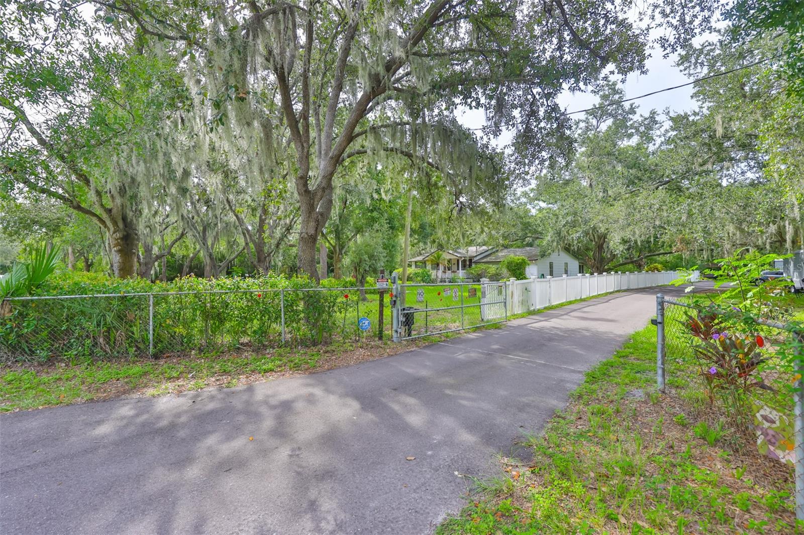 2.41 ACRE lot! PRIVATE setting in Gibsonton steps from the ALAFIA river! Gated and fully fenced setting with no deed restrictions--this property offers the lifestyle of quiet country living with the convenience of a quick ~20 min commute to downtown Tampa! LOVE the water? Drop your watercraft into the Alafia River to float into the BAY or dine dockside just minutes from home! This 1632 SF, one story home sits on a BEAUTIFUL Fl landscaped property featuring a front porch, 180 SF back deck off of the kitchen + a covered & screened rear lanai from the family room! Plenty of room here for your toys, boat, the RV, a garden and more! There are 2 sheds on the property--one with finished interior, electric/power, insulation + a ladder to a loft! The property is double fenced with 2 double gates in the rear for trailer/RV access. Big dollar updated items include: Roof 2021, Attic Insulation 2022, Gutters (2021) with Leafguard (2022), HVAC 2019 with new ducts (2022) & UV air purification system (2021), septic and drain field 2024, & driveway re-paved 2023. Step inside to find a comfortable 3 bedroom/2 bath floorplan featuring an oversized ~500sf family room with wet bar! Recent interior upgrades include granite kitchen countertop with double sink & faucet (2024), new kitchen range (2024), garbage disposal (2025), & kitchen recessed lighting (2023). The kitchen showcases white kitchen cabinets with mosaic tile backsplash, cabinet hardware, undermounted lighting, a rolling island, whirlpool fridge and a pantry! Light, neutral colored luxury vinyl plank flooring throughout most of the home; carpets only in the bedrooms! This is a prime location for access to I75, Downtown Tampa, Apollo Beach, Alafia River access, public transportation & Gibsonton Elementary School 0.2mi from home! Flood insurance is only ~$1100/yr! No flood issues here- no flood claims- sheds are anchored for hurricane weather! Long driveway, carport and parking pads provide plenty of parking for homeowners and guests! Oversized lots in this area are a RARE FIND! ASK FOR THE UPDATE/FEATURE SHEET and check out the ZILLOW Showcase tour!