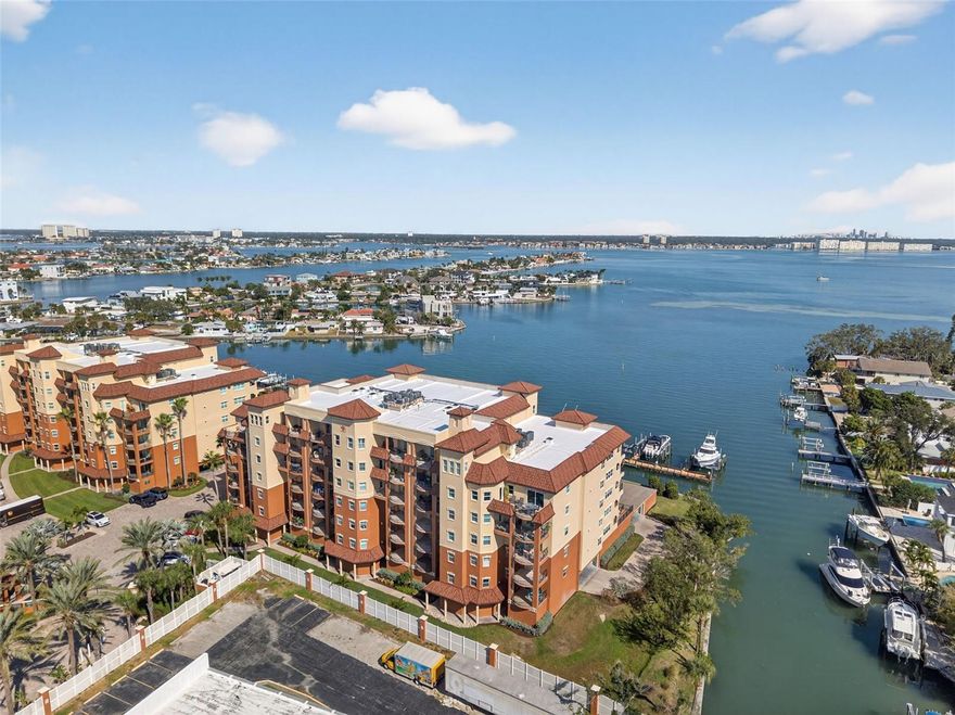 Wow, wow, wow… and yes, you really do get all this in one condo.
Welcome to your luxury waterfront escape on the magnificent Boca Ciega Bay, tucked inside an exclusive gated community where the views are grand and the vibes are pure Florida. These highly sought after Garden units with elevator access rarely hit the market so if you’re reading this, congratulations, you’ve already got great timing.
Step inside to a spacious, beautifully upgraded home featuring sleek tile floors, marble countertops, hurricane windows, water softener and a wide open floorplan that frames those gorgeous water views from the living area, kitchen, and owner’s suite. Morning person? Grab a coffee and get lost on your massive 400 sq. ft. patio watching the sun rise over the bay. Not a morning person? No problem head on over to the west facing balcony in the evening and let the sunset do the work.
You’ll love the key controlled semi-private elevator (because who wants to juggle groceries and stairs?), elegant tray ceilings, a relaxing soaking tub, and a versatile bonus room perfect for a cozy sitting area, craft room, sewing room, or home office. Add in a private in unit laundry room, walk-in pantry, and a 2-car garage, and you’ve officially run out of reasons to complain.
Location? It doesn’t get better. Beach access is directly across the street, with restaurants, Pass-A-Grille, shopping, and entertainment just moments away. This is the luxury Florida lifestyle people daydream about at their desks. Close to Gulf of America and only 20 miles to Tampa International airport too. 
Put this one at the top of your list and schedule your private viewing today before someone else decides this is their new happy place. Your own two car garage is under building.