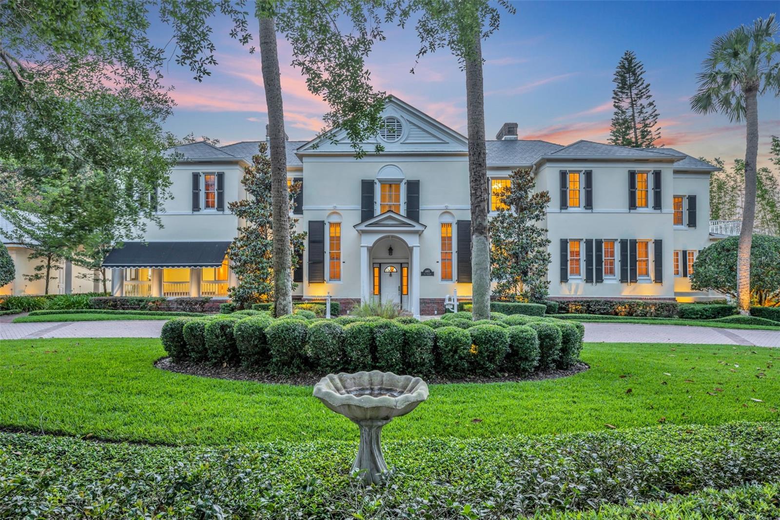 Proudly presenting a unique opportunity to acquire one of the most significant lakefront estates in Winter Park, on beloved Via Tuscany, moments from downtown Park Avenue's shopping and restaurants. This iconic and historic property boasts the rarity of 1.57+ acres elevated above Lake Maitland, with 138 feet of waterfrontage and breathtaking views from sunrise to sunset. Built in 1919 in the Georgian Revival style, the home captures the essence and elegance of a bygone era but is resplendent in every aspect to withstand the test of time. Spectacular curb appeal with stunning mature landscaping, a park-like backyard with a gazebo and sweeping lawn to the lake, a boat dock, an outdoor fireplace, and an impressive screened indoor pool provide endless enjoyment and entertaining possibilities. The grand entry foyer welcomes with a balance of informal and formal rooms on the first floor, ideal for large-scale entertaining, both inside and out. The first floor features an oversized living room, a formal dining room, a den, a study, a kitchen, a breakfast room, a Butler's pantry, and two sunporches. Two sets of staircases lead to 5 bedrooms and 4 full baths, plus numerous flex spaces. The upstairs owners' suite is luxurious with a fireplace, a sitting area, oversized walk-in closets, a small bar area, a closet with a second washer/dryer, elevator access, a private porch, and a rooftop terrace. There is also a guest cottage with a bedroom, a bathroom, a living room, and a kitchen. The enormous attic and basement offer large amounts of storage. Features include soaring ceilings (12-14'), heart pine floors, plantation shutters, an elevator, intricate millwork and crown molding, and a 4-car garage. The total of 8,353 heated square feet includes 7,367 sq ft in the main house and 986 sq ft in the guest cottage. The property has been meticulously maintained and enormously loved. Prime location and unrivaled lot quality.
