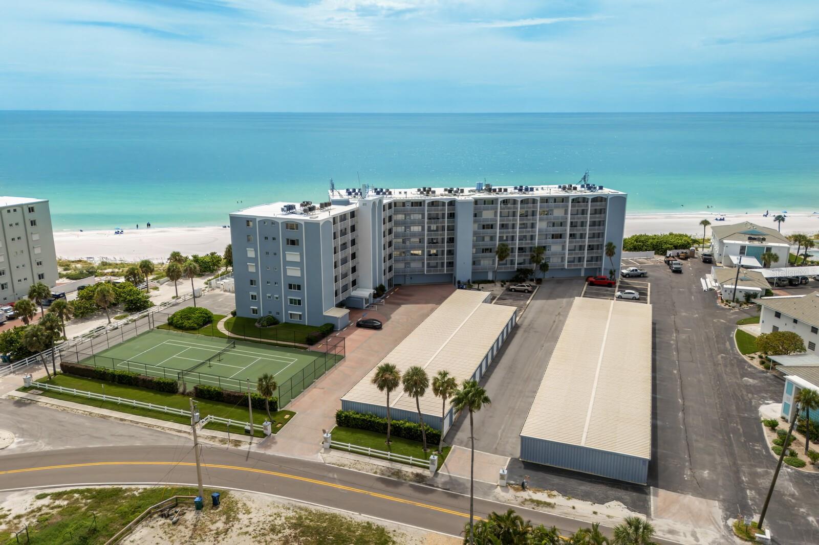 Soaring above the coastline on Anna Maria Island, this rarely available 5th floor condo at the Martinique delivers a front row seat to one of the most spectacular views on the Gulf Coast. Expansive windows in the living area and primary suite frame an endless horizon of blue, casting natural light across the updated interiors. The layout is open and easy, with two spacious bedrooms, two full baths, and a breezy coastal feel throughout. The kitchen features sleek stone counters, shaker cabinetry, and a wide breakfast bar perfect for laid back dining or entertaining. Just outside, you’ll enjoy resort style living with a large heated beachside pool, tennis courts, and private beach access to one of the most gorgeous beaches in Florida. You'll also appreciate the added bonus of your own deeded garage and separate storage unit for all the beach gear, bikes, and extras. Whether you're watching the sunset from your living room, soaking in the sun on the sugar sand beach or strolling to nearby shops and restaurants, this is the kind of place that makes every day feel like a vacation.