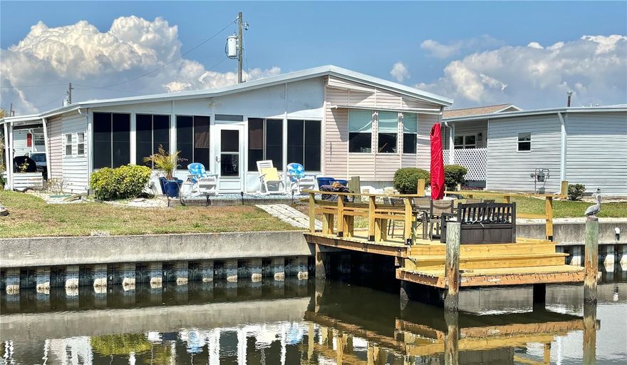 Enjoy waterfront living in this 1994 home featuring 2 bedrooms, 2 bathrooms, and nearly 1,000 sq. ft. of living space—plus an additional 264 sq. ft. Florida room. The home offers multiple indoor and outdoor gathering areas, including an updated dock (2026). The open-concept kitchen, living, and dining area creates a bright, airy feel, while the formal living room provides serene water views. Major updates bring peace of mind: the home experienced no water intrusion during the 2024 hurricanes, and all affected areas beneath the home have been remediated with a new vapor barrier, A/C ducts, and a new water heater. Kitchen features refinished countertops with modern stainless steel appliances, including a stove, oven, range, and microwave (2023), plus a refrigerator and dishwasher (2022). Additional upgrades include the HVAC system (2020) and the roof-over (2015). Flooring is laminate throughout the main living areas and bedrooms, waterproof vinyl in both bathrooms, and ceramic tile in the Florida room. Stylish barn doors allow the Florida room to easily function as a private guest space or home office. Outside, you’ll find a spacious 16’ carport that comfortably accommodates two vehicles and a golf cart, along with a large shed housing the washer and dryer.  Price includes the share for the lot and ownership in the community.
Located in Americana Cove, a premier 55+ factory-built housing community. A low monthly maintenance fee of $410 includes water, sewer, trash pickup, lawn care, a 24-hour manned gate, private streets, and full access to all community amenities. Enjoy easy access to downtown St. Petersburg in just 10 minutes and two airports within 15 minutes. Proof of funds or lender pre-approval is required with the contract. Community approval requires a minimum 675 credit score for each owner.