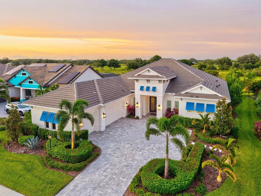 Not every home is simply built to be lived in; the most exceptional are crafted to be experienced. We invite you to discover this prestigious custom-built Lee Wetherington architectural masterpiece in LakeHouse Cove at Waterside. This home offers a floor plan that celebrates both scale and intimacy, set against the rare privacy of a protected preserve. Crafted with precision and curated with intention, it reflects the sensibilities of owners who value refinement at every turn. Step through the glass entry into soaring twelve-to-fourteen-foot ceilings, framed by expansive niches, custom lighting, and wide crown detailing. Walls of pocketing glass disappear and blend the interior with the outdoors in a way that feels effortless yet striking. Engineered wood floors flow through open living spaces, while an Arhaus Dandelion chandelier anchors the main gathering room with quiet drama. The kitchen is designed as both a showpiece and a place of purpose. Café Platinum appliances, including a five-in-one Advantium oven, and the custom wood hood and mantle elevate the space. A Ruvati forty-five-inch workstation sink takes functionality to a new level with the Dual-Tier collection that converts your sink into a full workspace. Heavy-duty cookware drawers and a walk-in pantry with custom carpentry ensure beauty and function remain in balance. The designer backsplash is an opulent luster that rivals mother-of-pearl, infused with flare straight from the sea and extending from counter to ceiling, complemented by under-cabinet lighting and discreet outlets that preserve clean lines. The primary suite is a retreat defined by thoughtful scale and elegant finishes. Two oversized walk-in closets with mirrored dressing space adjoin a bath featuring dual vanities, a deep soaking tub, and a triple-head shower with dedicated lines for comfort and performance. Two additional ensuite bedrooms, an office framed by solid core double pocket doors, and a versatile bonus room complete the interior. Beyond its beauty, this home is engineered for lasting comfort. PGT Low-E impact glass, whole-house water filtration with salt-free conditioning, a Navien tankless system with rapid hot water, dual HVAC air handlers, climate-controlled storage, and exterior security cameras with NVR reflect a commitment to quality. The outdoor living environment enhances the sense of privacy with its preserve backdrop. The lanai becomes a destination of its own with a summer kitchen featuring an oversized grill, a fire table lounge, and generous dining space that invites gatherings of every scale. The custom pool, complete with waterfall, sun shelf, and programmable lighting, transforms the setting into a resort-inspired centerpiece. Professional landscaping with dramatic uplighting frames the residence, ensuring it shines just as brightly at night. LakeHouse Cove is a lifestyle shaped by thoughtful amenities and natural surroundings. Residents enjoy a resort-style pool, fitness center, and clubhouse, along with kayaking, pickleball, and bocce. Hop on the community water taxi to Waterside Place or head to the boathouse to use the community kayaks. Acres of preserve and miles of shoreline create a natural rhythm, while Waterside’s vibrant lakefront town center offers dining, culture, and convenience within moments of home. This residence is a rare opportunity to own a home where architectural artistry, meticulous craftsmanship, and an extraordinary lifestyle come together in harmony.