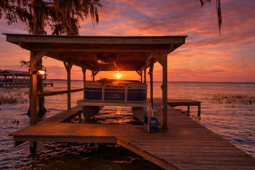 Positioned on the Harris Chain of Lakes, this 2-bedroom, 2-bath home offers a rare combination of dual primary suites, water views in two directions, and direct lake access on Lake Eustis.

Inside, the layout is built for both comfort and flexibility, featuring two spacious primary bedrooms, each offering privacy and room to unwind. The living room is anchored by a large picture window framing sunset views over Lake Eustis, bringing natural light and waterfront scenery into the heart of the home.

Step outside to enjoy multiple vantage points of the water. The screened back patio overlooks Green Lake, while the private dock on Lake Eustis provides direct access to the Chain of Lakes, complete with a boat lift and seating area—ideal for evening sunsets or days on the water.

The 2-car garage adds functionality with retractable screen doors, creating a breezy workshop space during cooler Florida days.

Whether you’re looking for a full-time residence or a low-maintenance waterfront escape, this property delivers true lakefront lifestyle with versatility and views that are hard to duplicate.