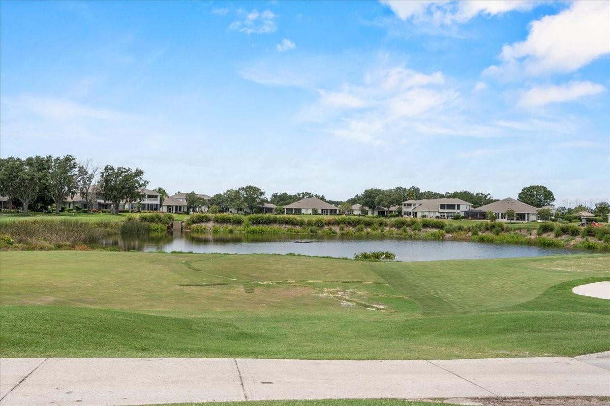Live the Country Club Lifestyle in Grasslands!
Welcome to this beautifully maintained 2-bed, 2-bath ground-floor condo in the exclusive, gated Enclave at Grasslands. Perfectly positioned on the first tee of the golf course, this home offers serene pond and sunset views from the kitchen, living room, primary suite, and screened lanai.
Enjoy designer upgrades throughout, including a custom eat-in kitchen with maple cabinetry, granite countertops, GE Profile appliances, Italian tile, and a walk-in pantry. The spacious primary suite features dual vanities, a custom glass shower, and a large walk-in closet.
Additional highlights include assigned covered parking, in-unit laundry, and access to a professionally managed condo association with monthly fees covering cable, water, sewer, exterior maintenance, and more. Grasslands Golf & Country Club amenities—including golf, tennis, pickleball, and a pool—are just a short walk away (membership required).
Located near Lakeside Village, medical centers, and major highways, this is resort-style living in the heart of Lakeland.