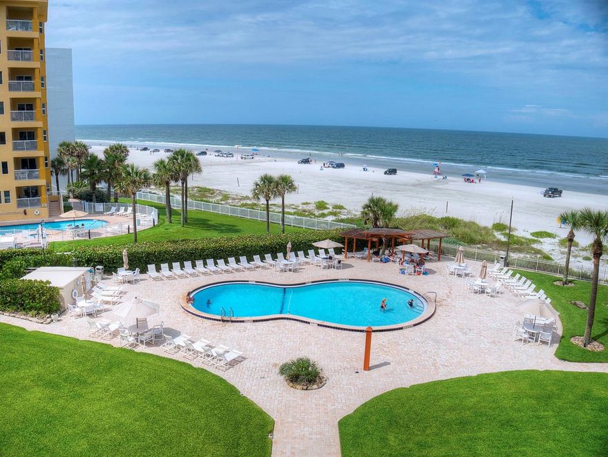 Imagine yourself in paradise, imagine yourself here at the Golden Arms.  This incredible 2/2 condo directly on the glimmering sands of New Smyrna Beach sits on a point, so it offers picturesque views of the ocean from the nearly every room. The spacious living area and the huge master bedroom both feature incredible views of the ocean as well as access to the balcony where you can bask in spectacular sunrises and warm summer breezes.  Whether you are looking for your new permanent home, a place to get away or are looking to invest, this beautiful condo is ideal.  The kitchen offers an easy to work in floor plan which overlooks the living area and YUP, more views of the ocean over a breakfast bar that seats 3-4 comfortably.   Amenities of the association include the pool, shuffleboard courts and a one car garage for the unit.  Pest control and building insurance are also included.  All located less than one mile from the dining, shopping, and entertainment of exciting Flagler Avenue.  Come for the fun, stay for the relaxation. Come home to the BEACH! ;LocationDescription: Condo ;Water: City