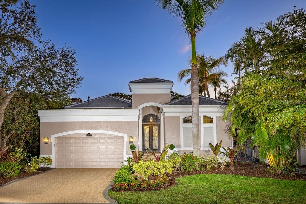 Experience all the best of what the island lifestyle can offer in picturesque Longboat Key, one of the desirable barrier islands of Sarasota. In the sought-after gated community of Bay Isles and Queens Harbour, this luxurious, tropically inspired residence offers two spacious exterior entertaining spaces. The well-designed floor plan wraps around a charming brick-paved courtyard with lush landscaping and picturesque palm trees as a backdrop for privacy and relaxation. A sparkling black-bottom pool offers a cool spot to rest, and a separate guest casita completes the courtyard. Enter the home’s grand entrance as it reveals a spacious, light-filled vestibule with a striking, curved staircase, a 20-foot ceiling, and panoramic views through an abundance of windows overlooking the spectacular Longboat Key Club golf course and lake. This exceptional residence offers a harmonious blend of luxury, comfort and timeless elegance in 4,000 square feet of living area. The exquisite interior details include grand 14-20-foot ceilings with tray and crown molding features, French doors, attractive built-ins and updated finishes throughout. A rare find, this home is ideal for multigenerational living, with two equally spacious 15-by-20-foot primary suites, with one on the first floor and the second, upstairs. Both primary suites offer walk-in closets and a luxurious spa-like bath. The upstairs suite sits adjacent to the bonus room loft, providing a TV/lounge room for guests, or children to have their space. Designed with entertaining in mind, the chef’s kitchen features Miele and Sub-Zero appliances, including a Wolf five-burner gas cooktop, ice maker and wine cooler. The beautiful quartzite countertops are backdropped by a gorgeous sea-colored glass tile backsplash and beautiful custom cabinetry. The formal living and dining rooms offer access to the second brick-paved patio that overlooks the fourth hole of the golf course and offers additional gathering spaces, a gas fire pit, and amazing lake and sunset views. Additionally, the first floor offers a spacious family room and an office with built-ins overlooking the courtyard. The secondary bedrooms offer private accommodations, walk-in closets and en-suite baths. Additional features include a new roof, new main air conditioner and tankless water heater! The Queens Harbour neighborhood is ideally behind the gates of Bay Isles and features a community heated pool. Residents enjoy a maintenance-free lifestyle and deeded access to Gulf of Mexico beaches with the Bay Isles Beach Club. The gated, private beach pavilion for residents includes barbecue, volleyball, parking, beach chair storage and restrooms. This wonderful home is available for private showings by appointment.