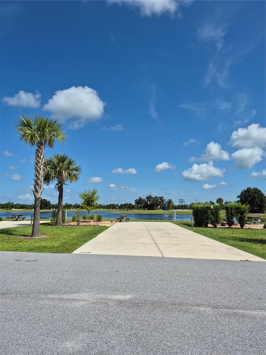 Welcome to the Resort at Canopy Oaks in Lake Wales, Florida! Set within a beautiful nature preserve, this premier RV destination offers resort-style amenities including a large pool and hot tub, 12,000 sq ft clubhouse, full-service tiki bar, on-site café and general store, pickleball courts, shuffleboard, bocce, fishing ponds, dog parks, and scenic walking trails. This deeded waterfront RV lot provides a peaceful, private setting with plenty of room to relax. The spacious 20’ x 70’ concrete pad includes full hookups (20/30/50 amp) and accommodates Class A, Class C, fifth wheels, travel trailers, or even a small park model—making it the perfect carefree seasonal retreat.