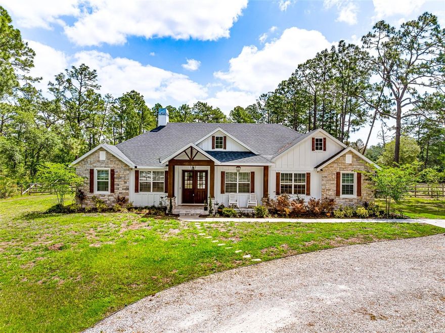 Just like a brand new builder's home, but it is ready to move into!  Built in 2021 and pool added in 2022.  Move-In Ready Home with Gorgeous heated salt water pool and spa located on a 1-acre Corner Lot on a cul-de-sac. If you are seeking maximum privacy, plenty of space, and tranquility, then this beautiful, well-maintained home in the established Royal Trails community is the perfect place for you! The current owners have lovingly cared for the property and completed several updates that will save you money and provide peace of mind for years to come. Arrive home to your tranquil paradise, greeted by abundant mature trees that provide the perfect blend of privacy and yet lots of area for the children to play. Turn into the expansive driveway, where this custom home, with its attractive stone facade and custom wood accents make it like no other home. You can park on the parking pad while still allowing many guests to find ample parking available on the oversized driveway. As you walk to the front entry, you will find a custom oversized glass door that welcomes you inside. The interior is infused with natural light from the expansive windows. Crown molding adorns the vaulted front ceilings and gorgeous wood-look tile floors in a walnut finish throughout the home. The front dining room and adjacent great room are spacious and provide a wonderful entertaining space for family gatherings and celebrations. The heart of the home is the open-concept great room complete with a woodburning fireplace, which features french doors that open onto the covered oversized 23x8 lanai. The well-appointed kitchen offers abundant wood cabinetry, stainless steel appliances, a large walk-in pantry, and a convenient breakfast bar. Their is a separate family room that is ideal for family games or movie nights. The split-bedroom floor plan ensures plenty of privacy for everyone. The primary suite features a glass slider to the lanai, one huge walk-in closet, and a private en-suite bathroom complete with a dual sink vanity, a tiled glass shower, and a deep jacuzzi soaking tub for ultimate relaxation. Two guest bedrooms with large closets share a full hallway bathroom that includes a tub/shower combination. Fourth bedroom is separated by the family room for privacy. There is also a separate office complete with Starlink Satellite for those work at home owners. Additional conveniences include abundant storage and an inside utility room and laundry closet as well as a GYM!. You will love both relaxing and entertaining on the expansive covered rear lanai overlooking the custom pool and spa, which is a fantastic space for grilling and dining ‘al fresco!’ The backyard offers plenty of room to create your perfect outdoor entertainment zone or zen garden. Complete with wooden Playset and Sandbox for the children; a Chicken Coop for those fresh eggs and the fabulous fire pit area complete with lights in the trees for relaxing with friends. Royal Trails residents enjoy deeded access to beautiful Lake Norris. Bring your boat, kayak, canoe, or fishing poles, or simply enjoy the enchanting views and nature. The zoning allows 2 horses an acre, RV, and boat parking. The community center in Royal Trails is available for reservation for larger gatherings. With peace and privacy surrounding you, every amenity is still just a short drive away. This is truly a gem. House has plug to allow the entire house to be generator operated.
