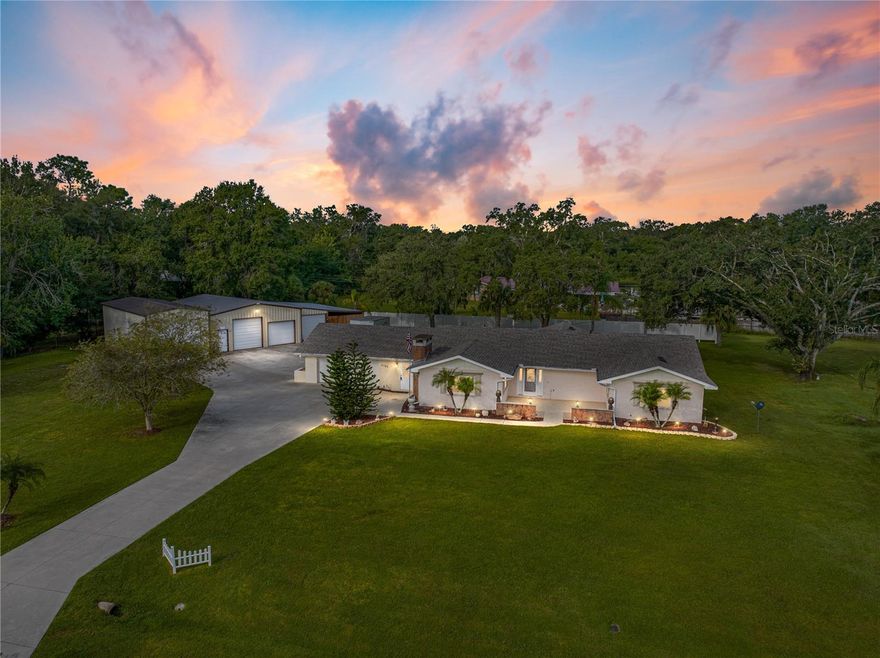 Welcome to a one-of-a-kind property where country living meets endless potential. This charming 3-bedroom, 2-bathroom home, nestled on a spacious one-acre lot, is a canvas for your dreams. The property comes complete with a multi car detached garage, a versatile workshop sized to fit RVs, boats, or any other tall vehicles, and a generous open-air workshop/pole barn, offering a lifestyle rich in space, versatility, and tranquility.  As you approach this unique residence, you're greeted by spacious courtyard at the front door, perfect for a set of rocking chairs or potted plants to add charm and warmth to the entry.  Inside, a warm and inviting atmosphere embraces you, with plenty of natural light to brighten your days.  The living room, kitchen, and dining area all connect, creating a space perfect for gathering with family and friends. It's the heart of the home, where stories are shared, and memories are made. The sunken family room is great for cozy conversations with a stone-clad wood burning fireplace. The living room has a large footprint, big enough for nearly any furniture configuration. The primary bedroom comes complete with a spacious walk-in closet and a full ensuite bathroom.  But while there’s plenty to love within the walls of this house, the true beauty of this property lies in its vast acreage and outbuildings. Step outside and envision the possibilities. Whether you're a hobbyist, a car enthusiast, or simply someone who values space and freedom, this acreage caters to your needs. The 1280 square foot 4-car detached garage is a haven for car aficionados or DIY enthusiasts. It offers ample space to house your vehicles, have a private workshop, and to embark on your next project. A secondary workshop with sky-high ceilings clocks in at 720 square feet, a dedicated space for hands-on creativity, from carpentry to crafts. Bring your ideas to life, and let your imagination run wild. The open-air workshop/pole barn is a blank canvas for your desires. Use it for additional storage, shelter your animals, or pursue your agricultural aspirations. The choice is yours. Surrounded by the beauty of nature, this property invites you to cultivate your own outdoor haven. Whether you envision a bountiful garden, a private orchard, or a peaceful retreat, this acre of land is your canvas. Your rural escape and dream lifestyle await. Seize this unique opportunity to make this versatile property your own.